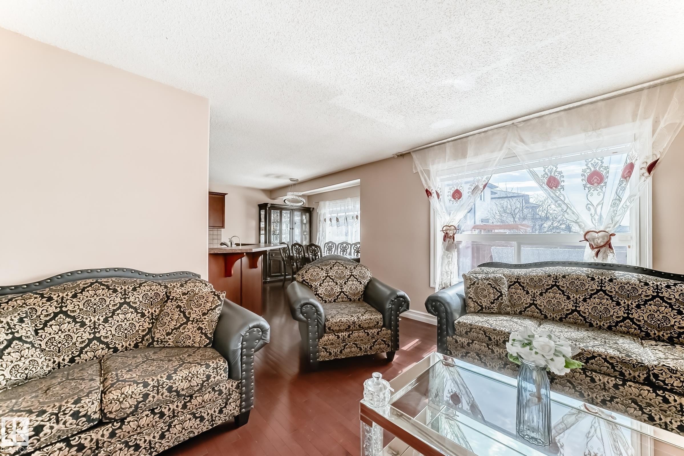 The living area features hard flooring, light-colored walls, and a large window providing natural light - 11415 167A Avenue Nw, Edmonton, AB - Indoor Photo Showing Living Room