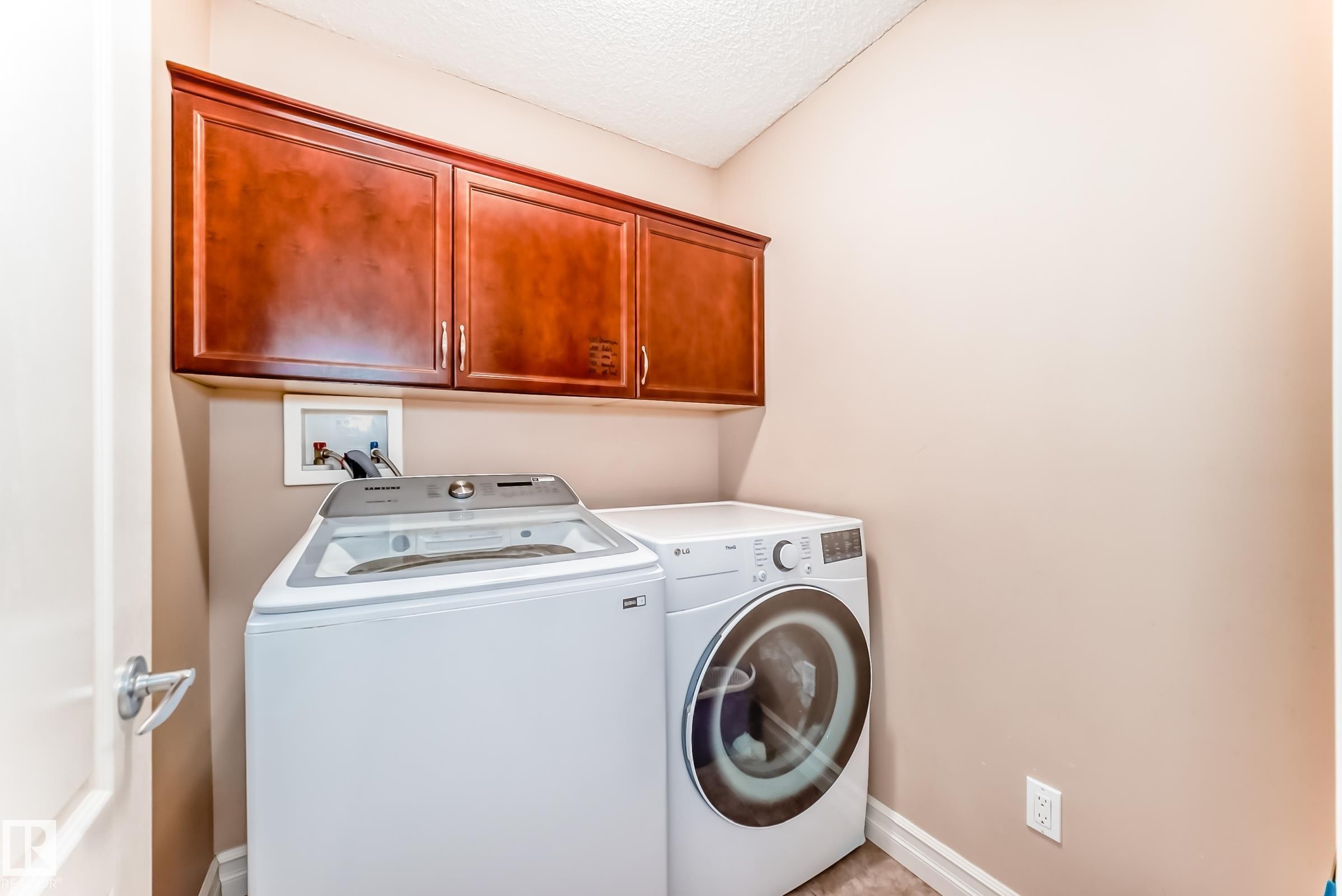 Laundry area featuring overhead wooden cabinetry - 11415 167A Avenue Nw, Edmonton, AB - Indoor Photo Showing Laundry Room