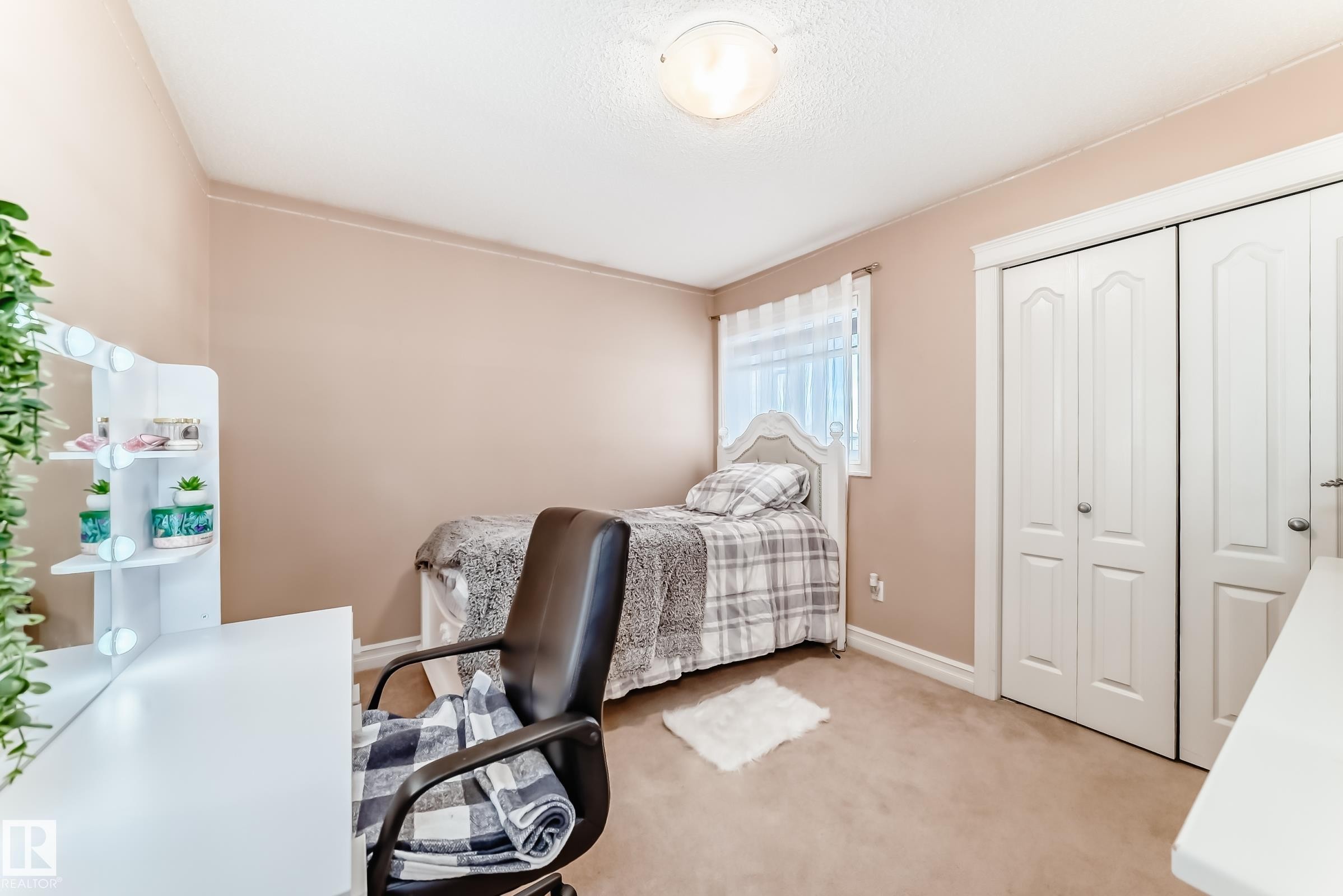 This room features a soft neutral wall color, carpeted flooring, and a window with sheer white curtains - 11415 167A Avenue Nw, Edmonton, AB - Indoor Photo Showing Bedroom