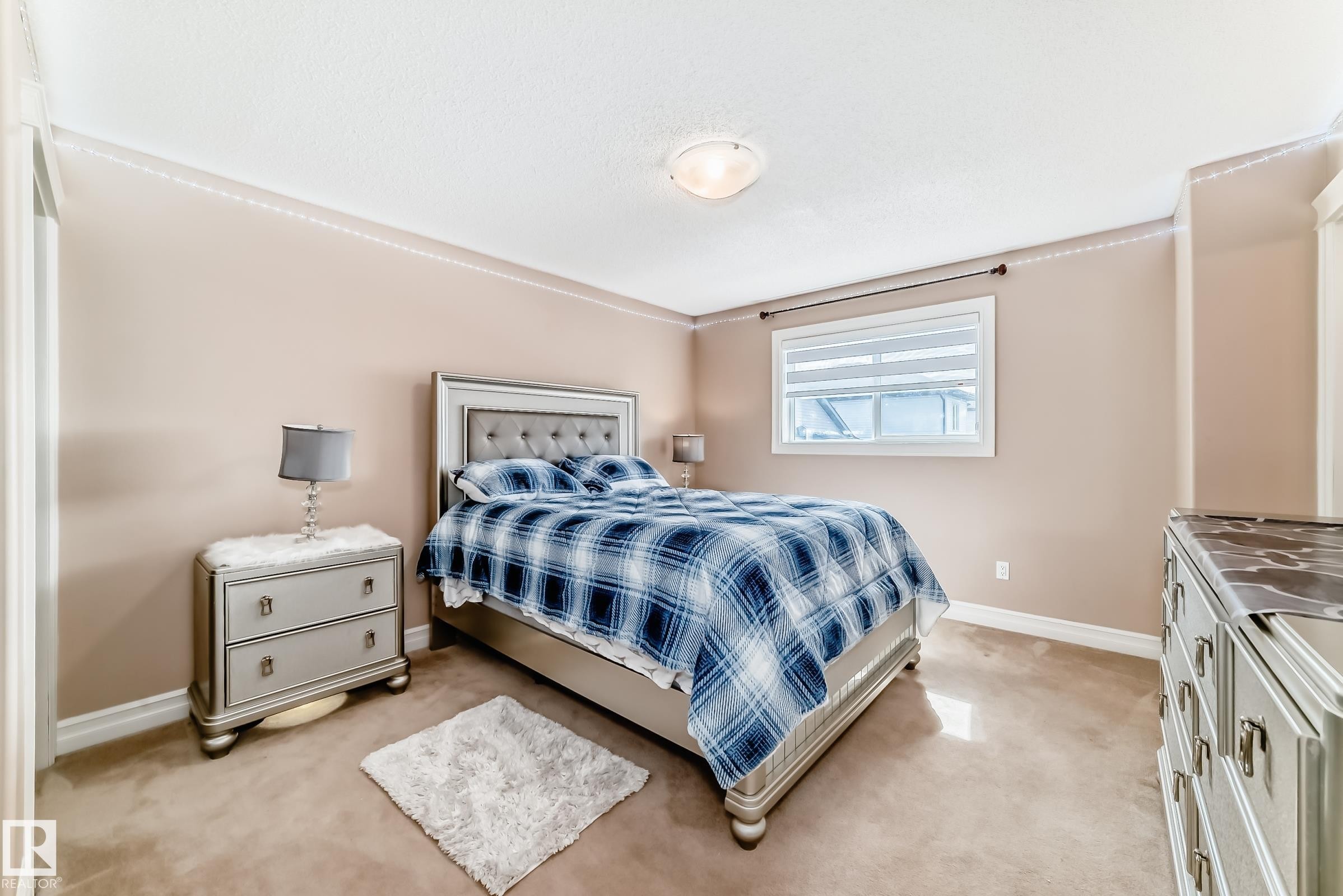 Spacious room with a window providing natural light, crown molding, and carpeted flooring - 11415 167A Avenue Nw, Edmonton, AB - Indoor Photo Showing Bedroom
