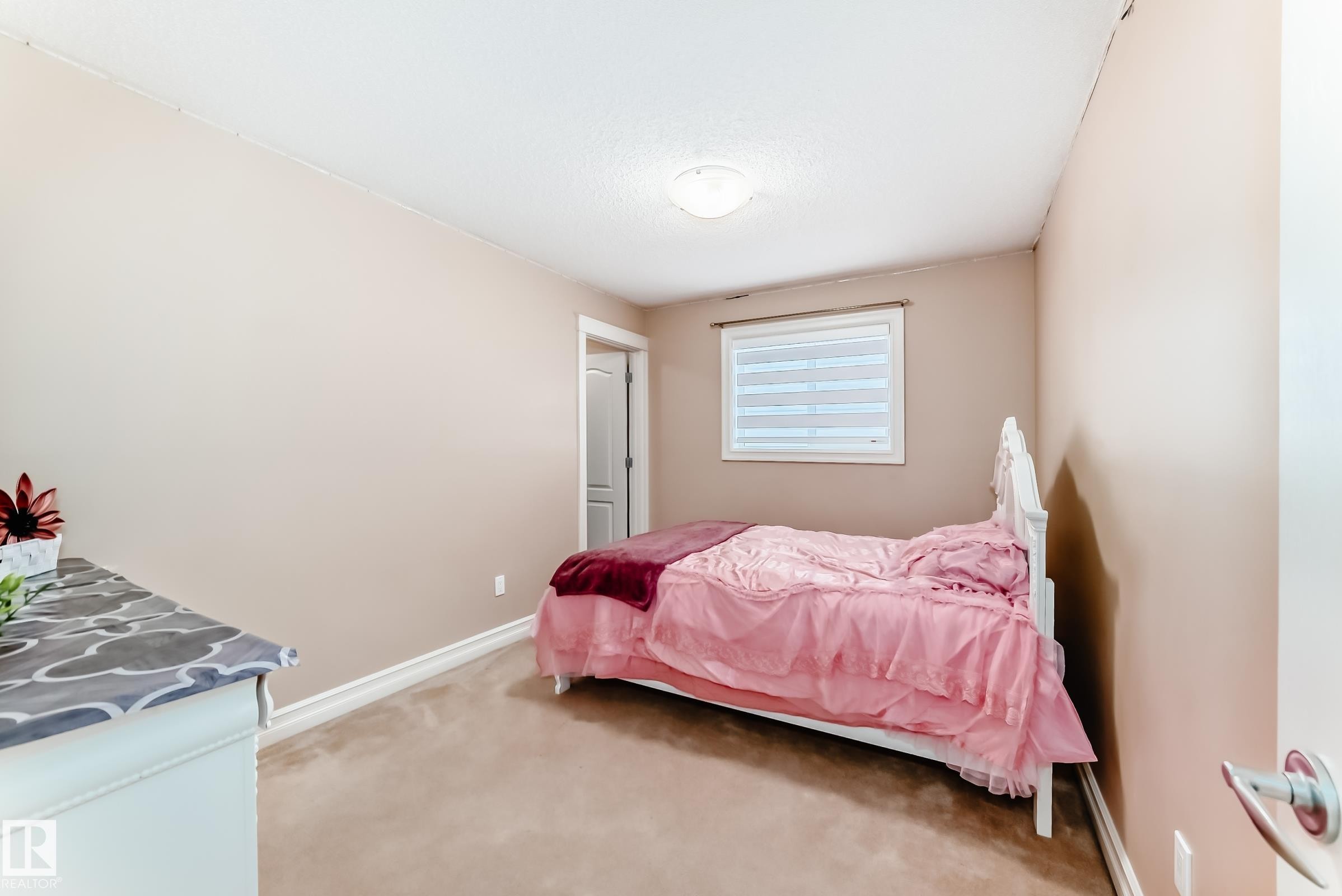 This room features a neutral wall color, carpeted flooring, and a window with blinds - 11415 167A Avenue Nw, Edmonton, AB - Indoor Photo Showing Bedroom