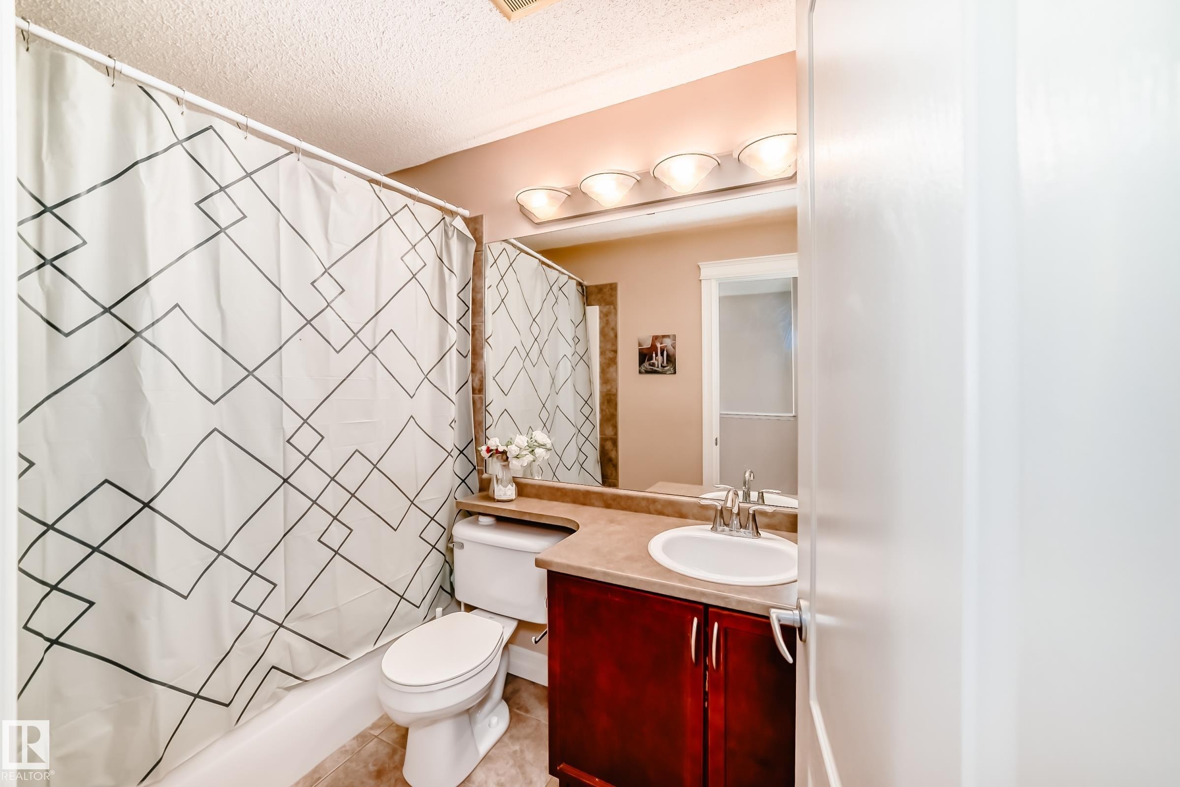 The bathroom features a vanity with a white sink, a mirror, and overhead lighting - 11415 167A Avenue Nw, Edmonton, AB - Indoor Photo Showing Bathroom
