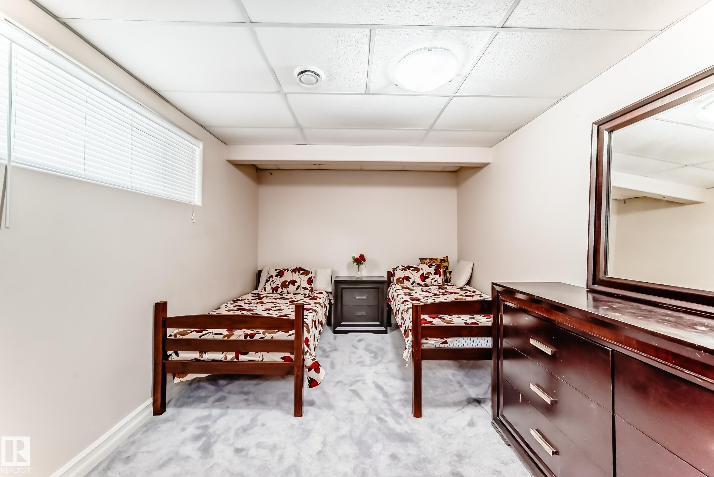 The room features a textured carpet flooring and a drop ceiling with recessed lighting - 11415 167A Avenue Nw, Edmonton, AB - Indoor
