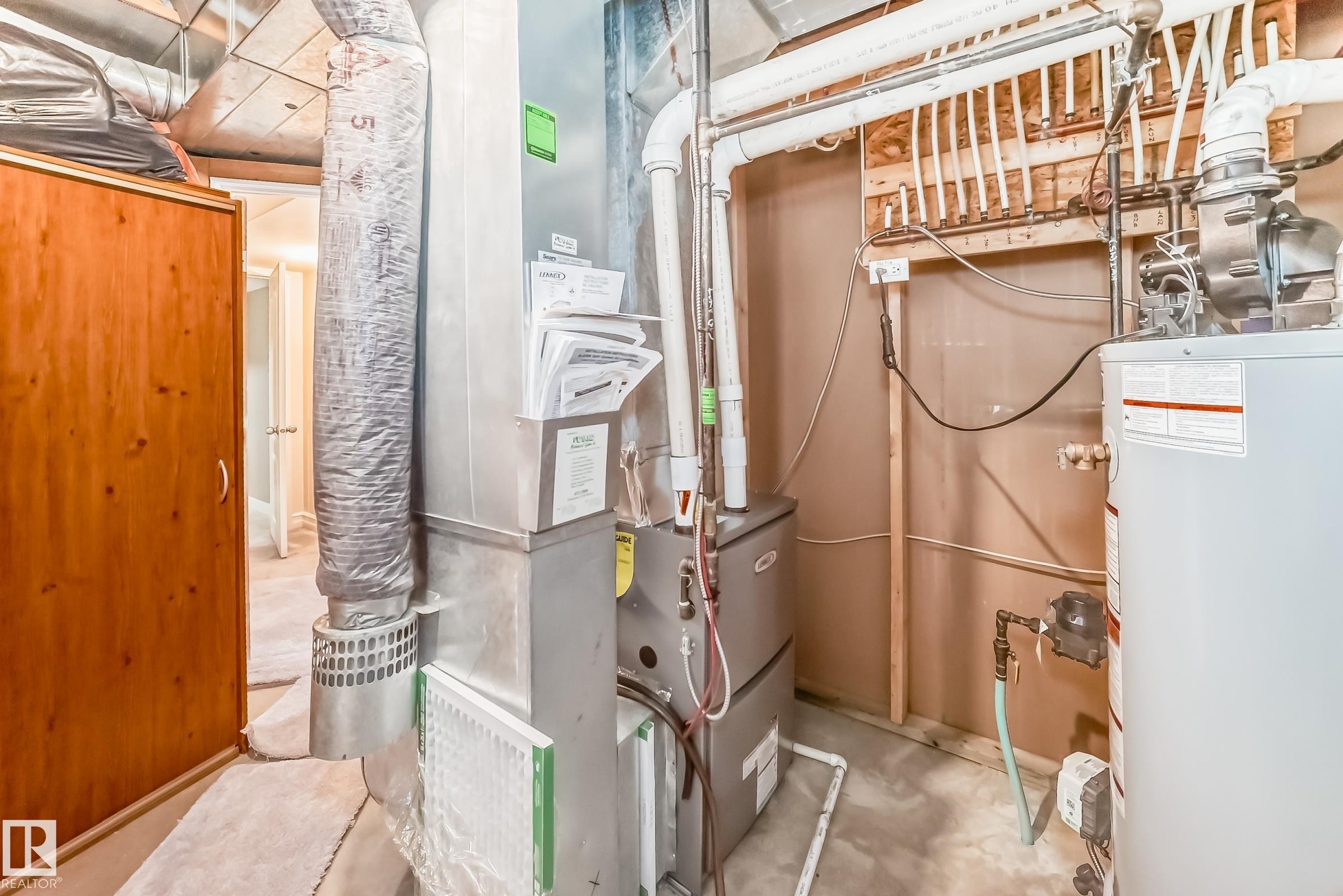 Property utility room featuring a water heater, furnace, and exposed ceiling ductwork - 11415 167A Avenue Nw, Edmonton, AB - Indoor Photo Showing Basement