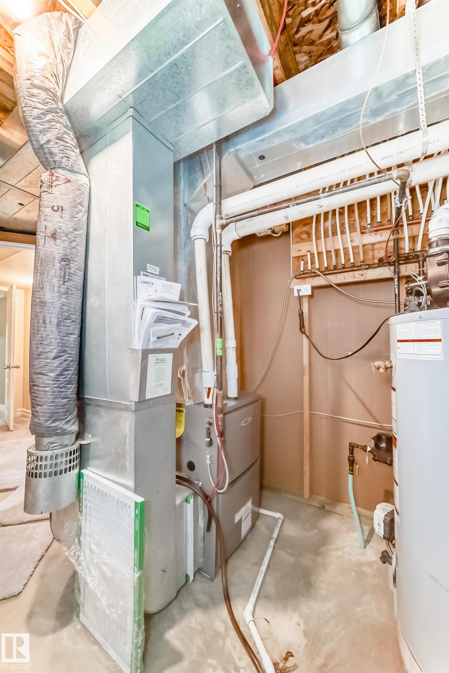 The property includes an HVAC system with extensive ductwork, a water heater, and a visible manifold system - 11415 167A Avenue Nw, Edmonton, AB - Indoor Photo Showing Basement