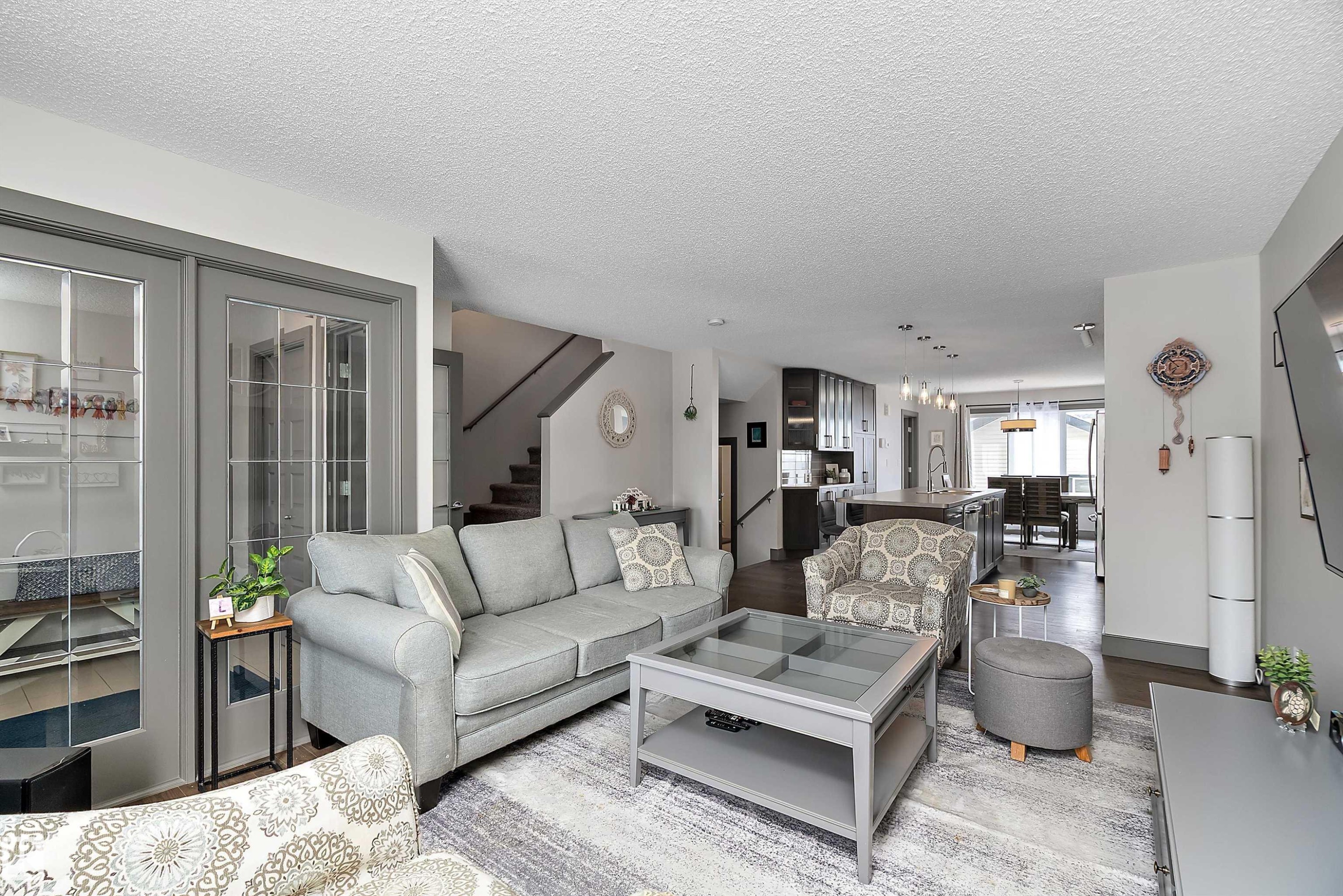 This inviting living area features light grey walls and hardwood flooring, creating a bright and airy atmosphere - 7776 Eifert Crescent Nw, Edmonton, AB - Indoor Photo Showing Living Room