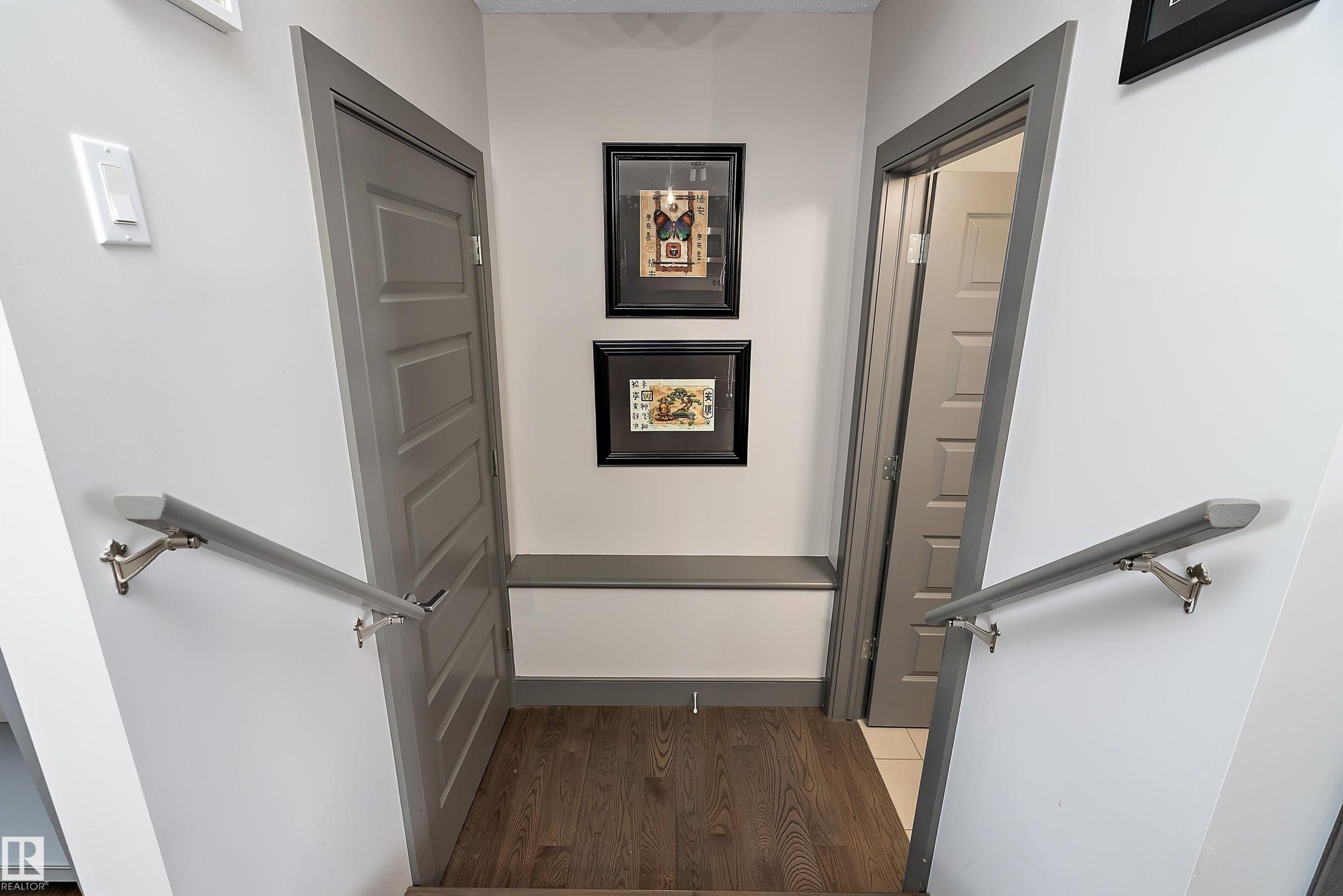 The interior hallway features hardwood flooring and light gray painted doors - 7776 Eifert Crescent Nw, Edmonton, AB - Indoor Photo Showing Other Room