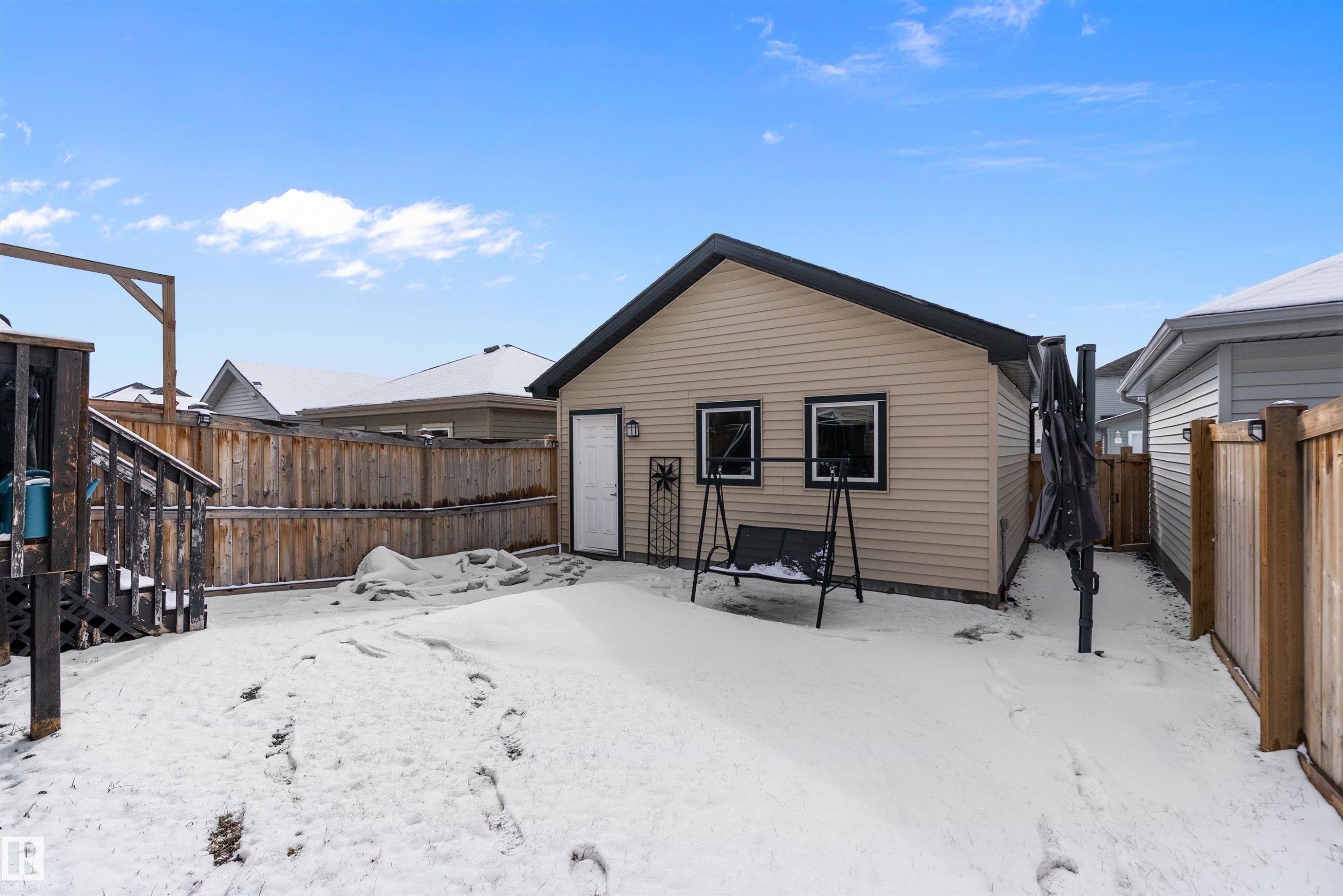 The property features a detached building with siding, a black roof, and exterior lighting - 7776 Eifert Crescent Nw, Edmonton, AB - Outdoor With Exterior