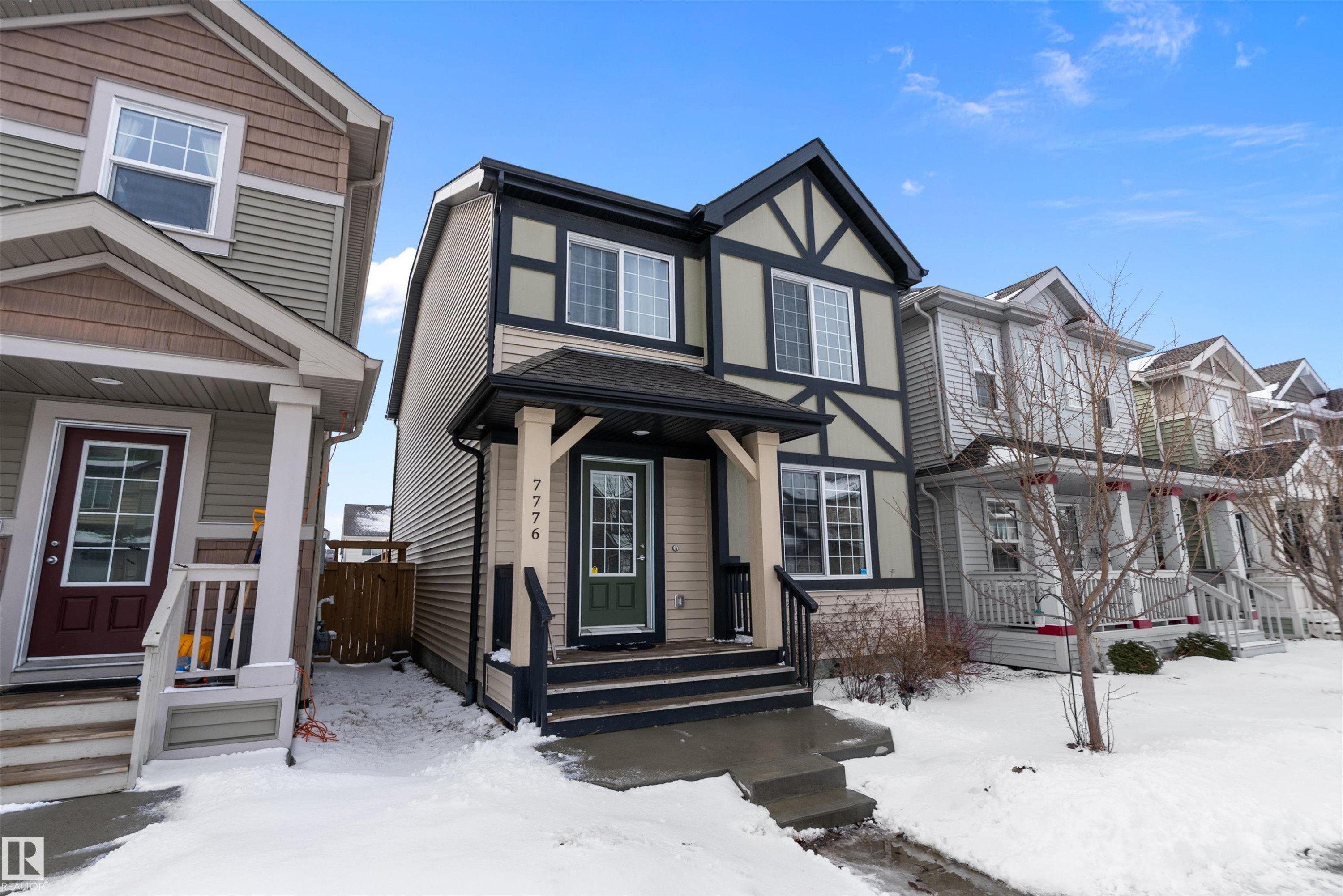 The property features a distinctive exterior with dark trim detailing, a covered front porch, and a contrasting front door - 7776 Eifert Crescent Nw, Edmonton, AB - Outdoor With Facade