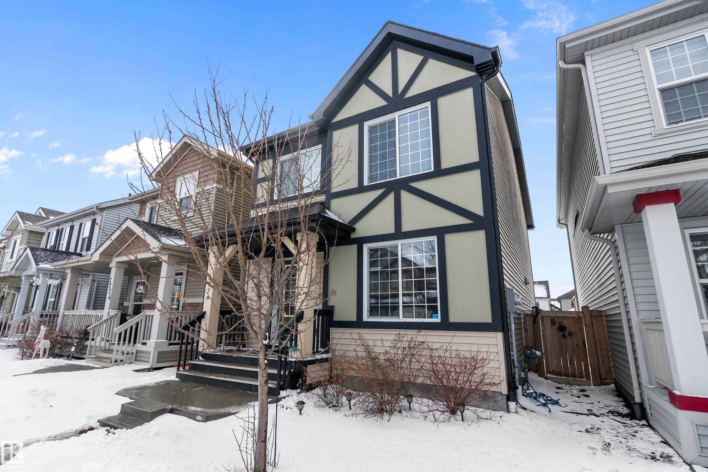 The property features a Tudor Revival style exterior with light-colored siding and dark trim - 7776 Eifert Crescent Nw, Edmonton, AB - Outdoor With Facade