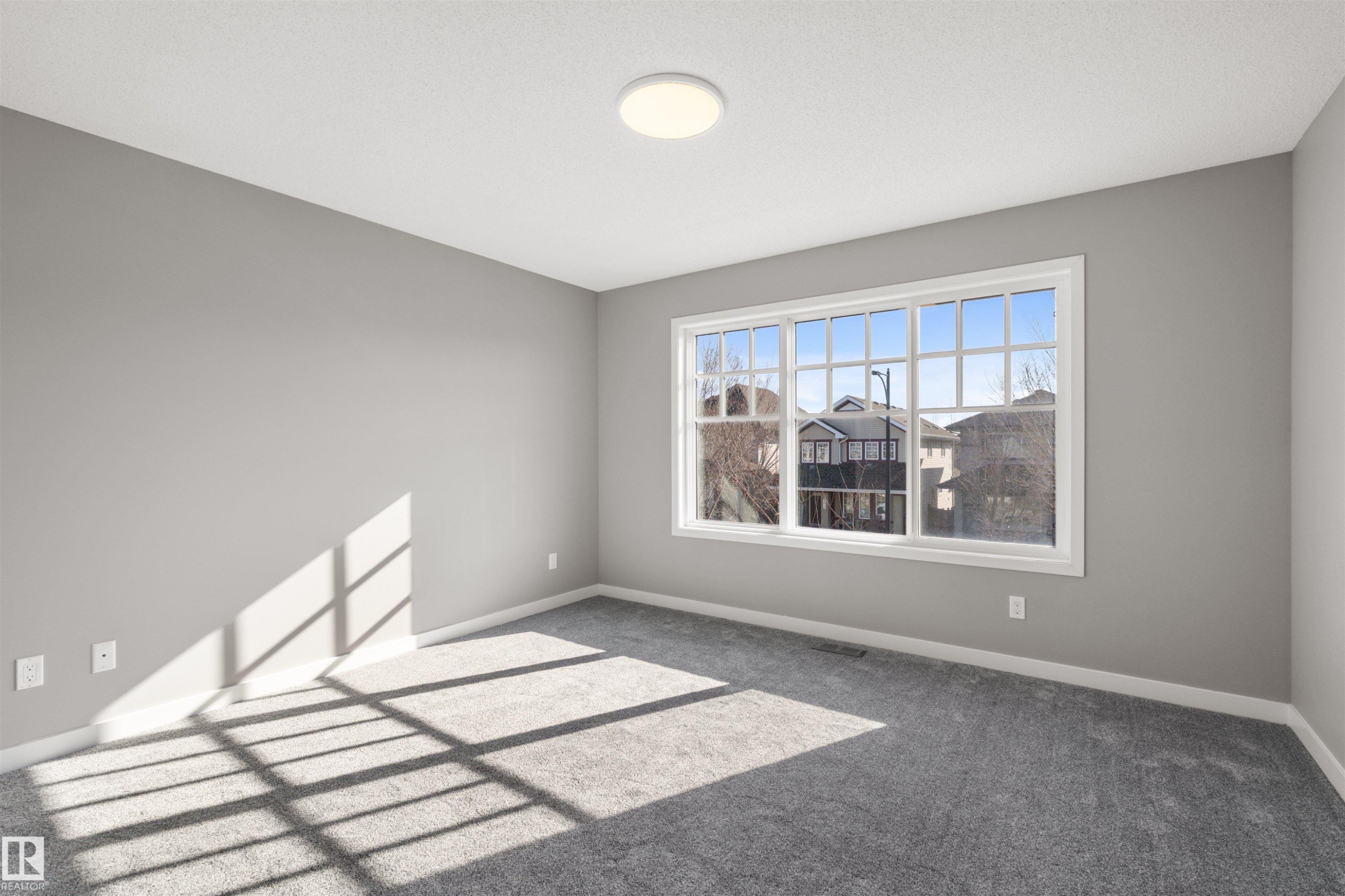 This room features a window providing natural light, light gray walls, and gray carpeting - 4016 Allan Crescent, Edmonton, AB - Indoor Photo Showing Other Room