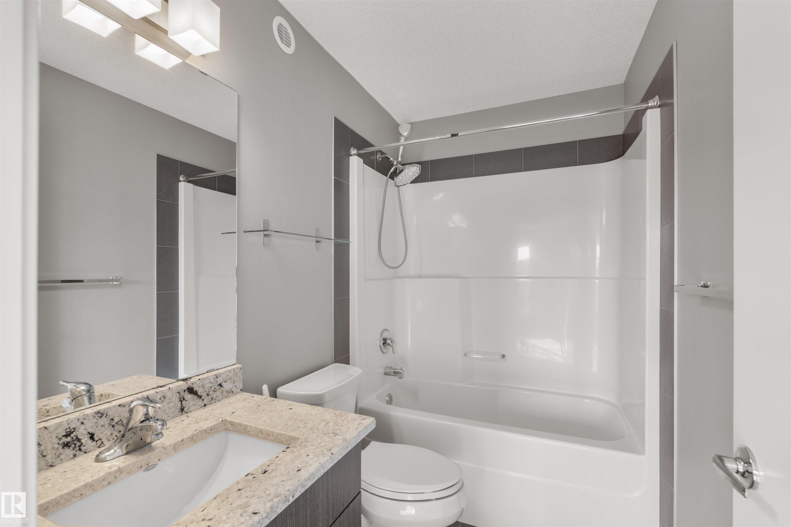 Bathroom featuring a vanity with a light-colored granite countertop, a white sink, and a chrome faucet - 4016 Allan Crescent, Edmonton, AB - Indoor Photo Showing Bathroom