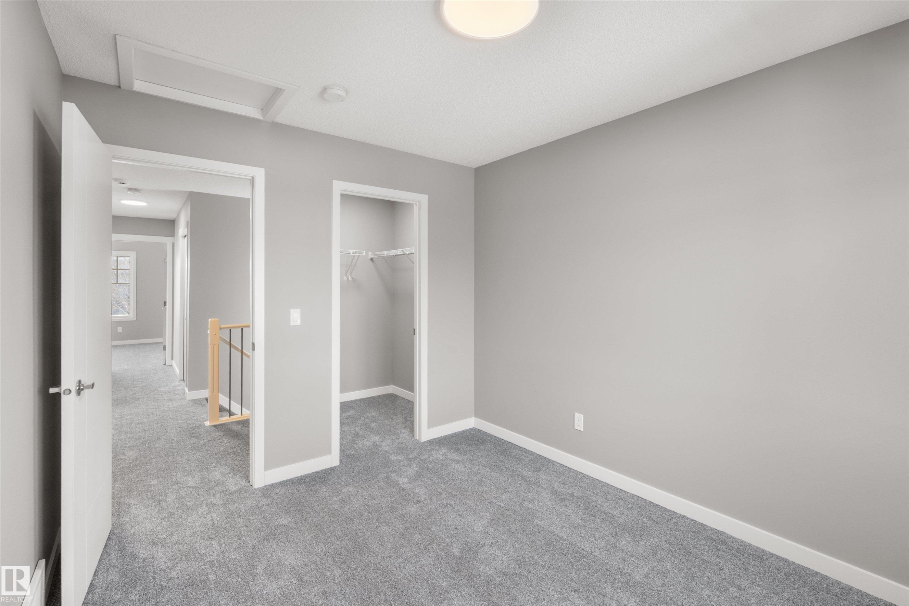This room features neutral gray walls, gray carpeting, a closet with a hanging rod, and a ceiling light fixture - 4016 Allan Crescent, Edmonton, AB - Indoor Photo Showing Other Room