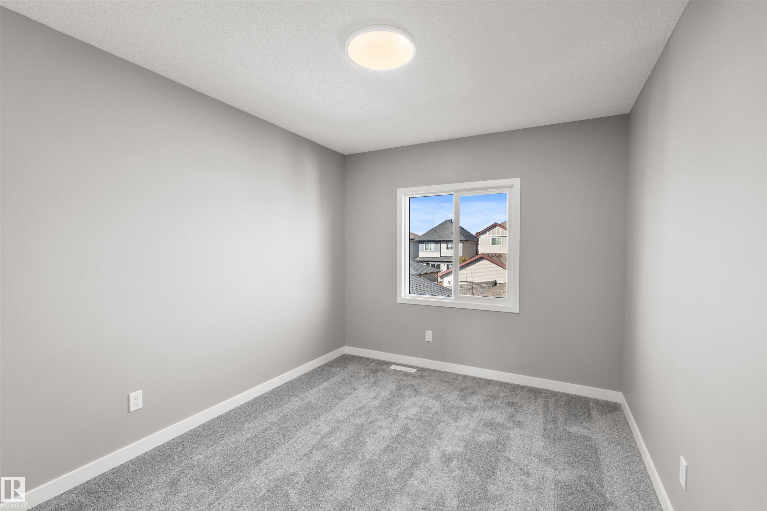 This room features light gray walls, a window with a white frame, and gray carpet - 4016 Allan Crescent, Edmonton, AB - Indoor Photo Showing Other Room