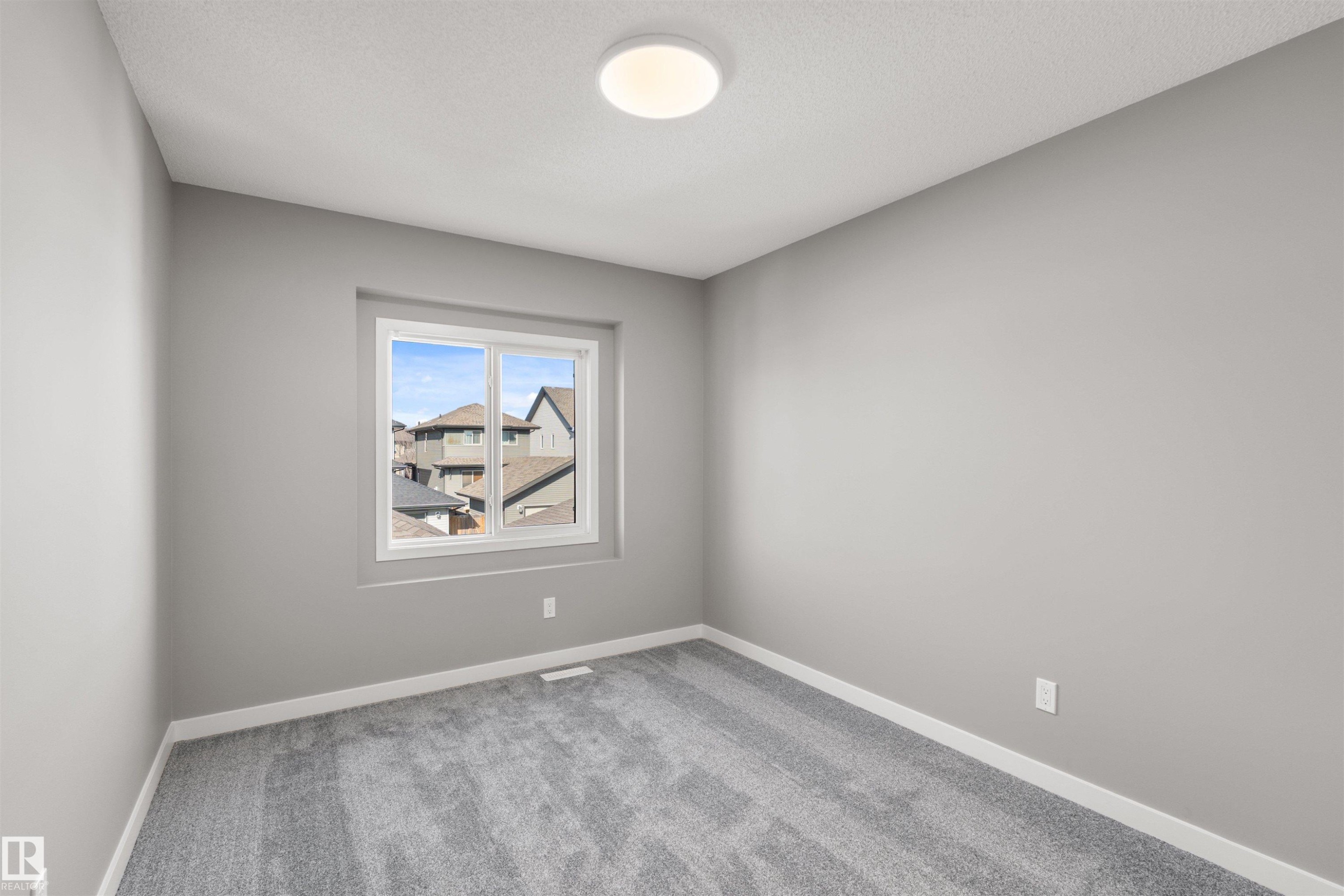This room features light grey walls, a window providing natural light, and grey carpeting - 4016 Allan Crescent, Edmonton, AB - Indoor Photo Showing Other Room