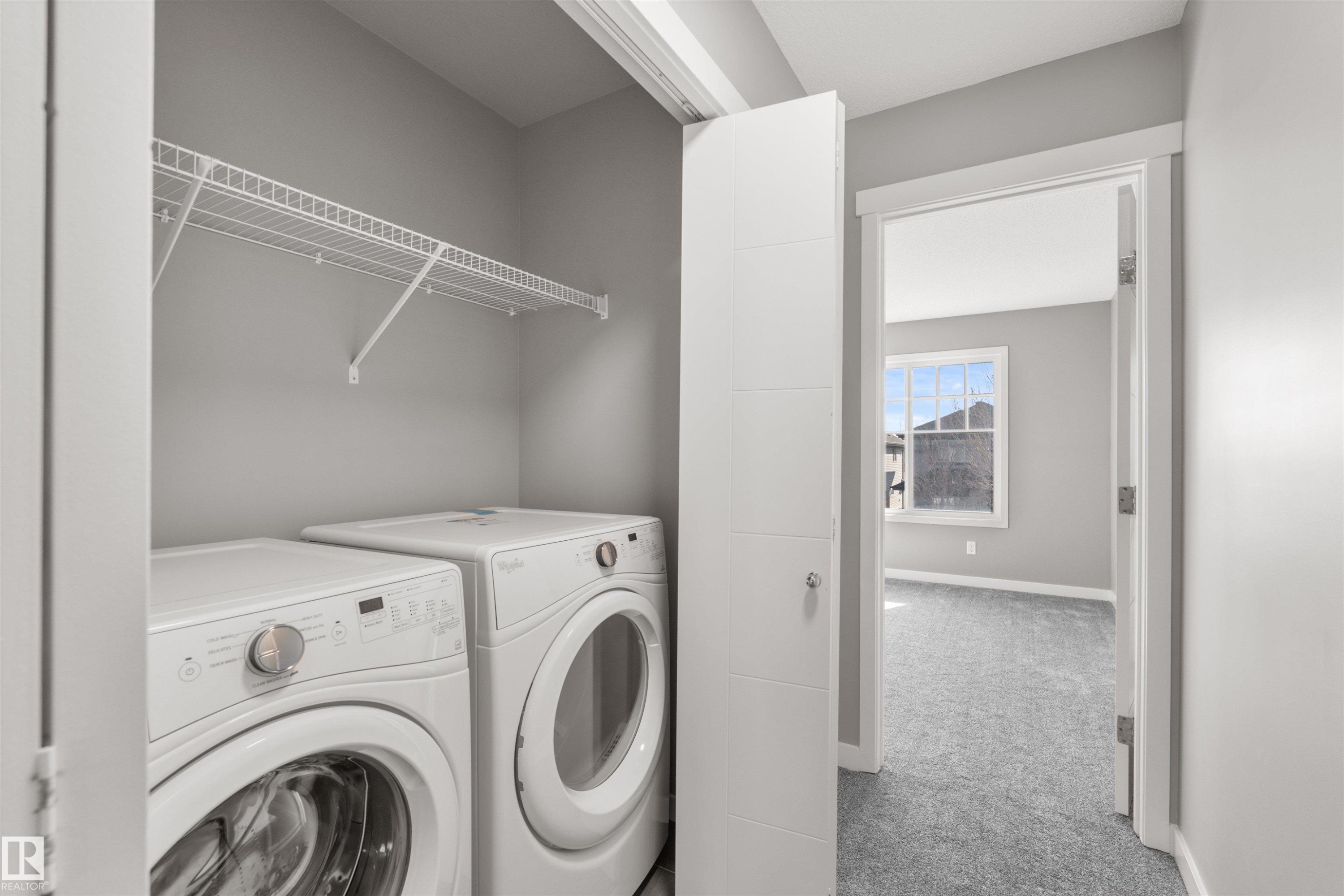 This utility area features a clothes washer and dryer, with a wire shelf for storage - 4016 Allan Crescent, Edmonton, AB - Indoor Photo Showing Laundry Room