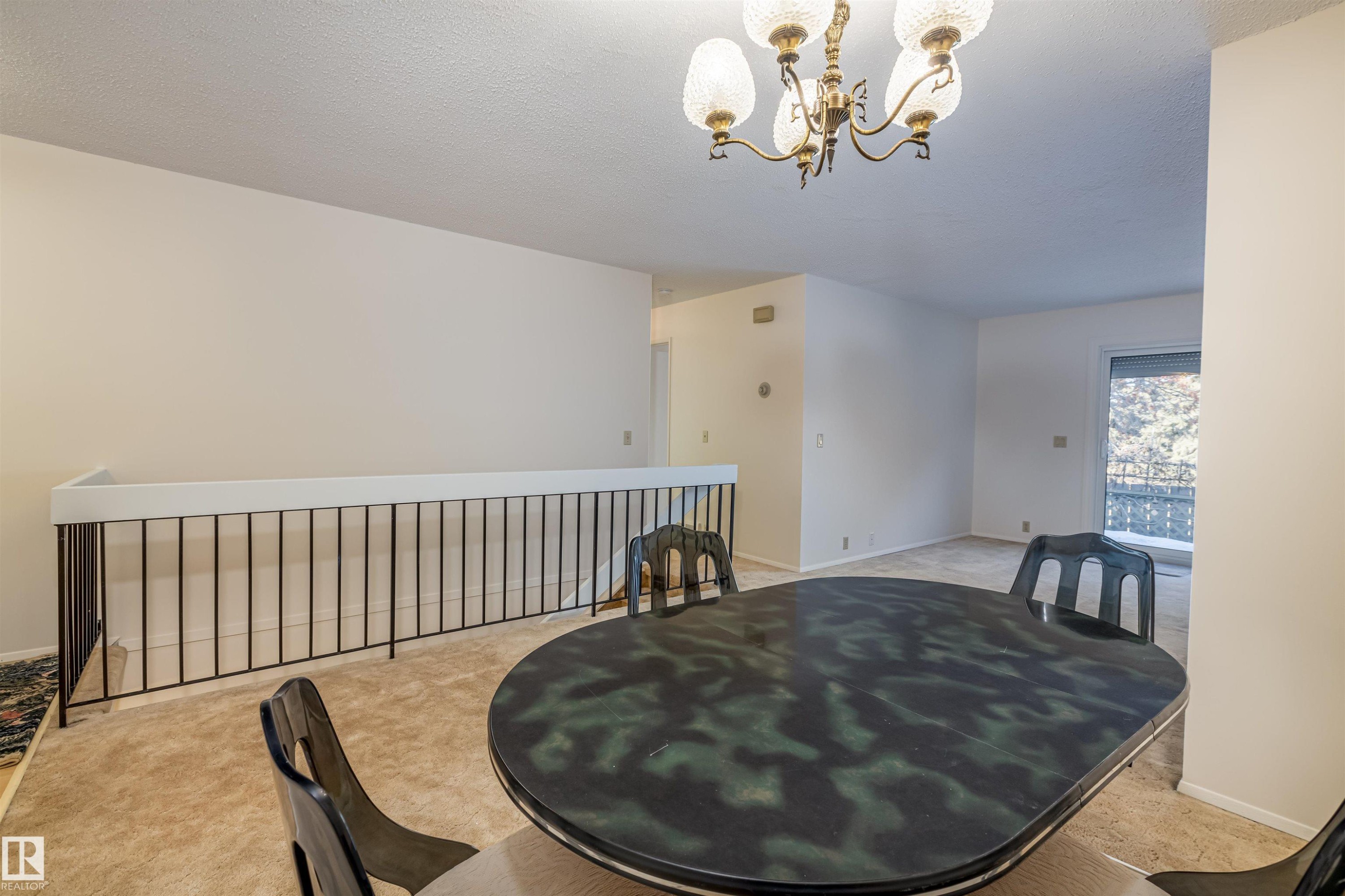 The property features a dining area with a chandelier and carpeted flooring - 108 Forest Grove, St. Albert, AB - Indoor Photo Showing Dining Room