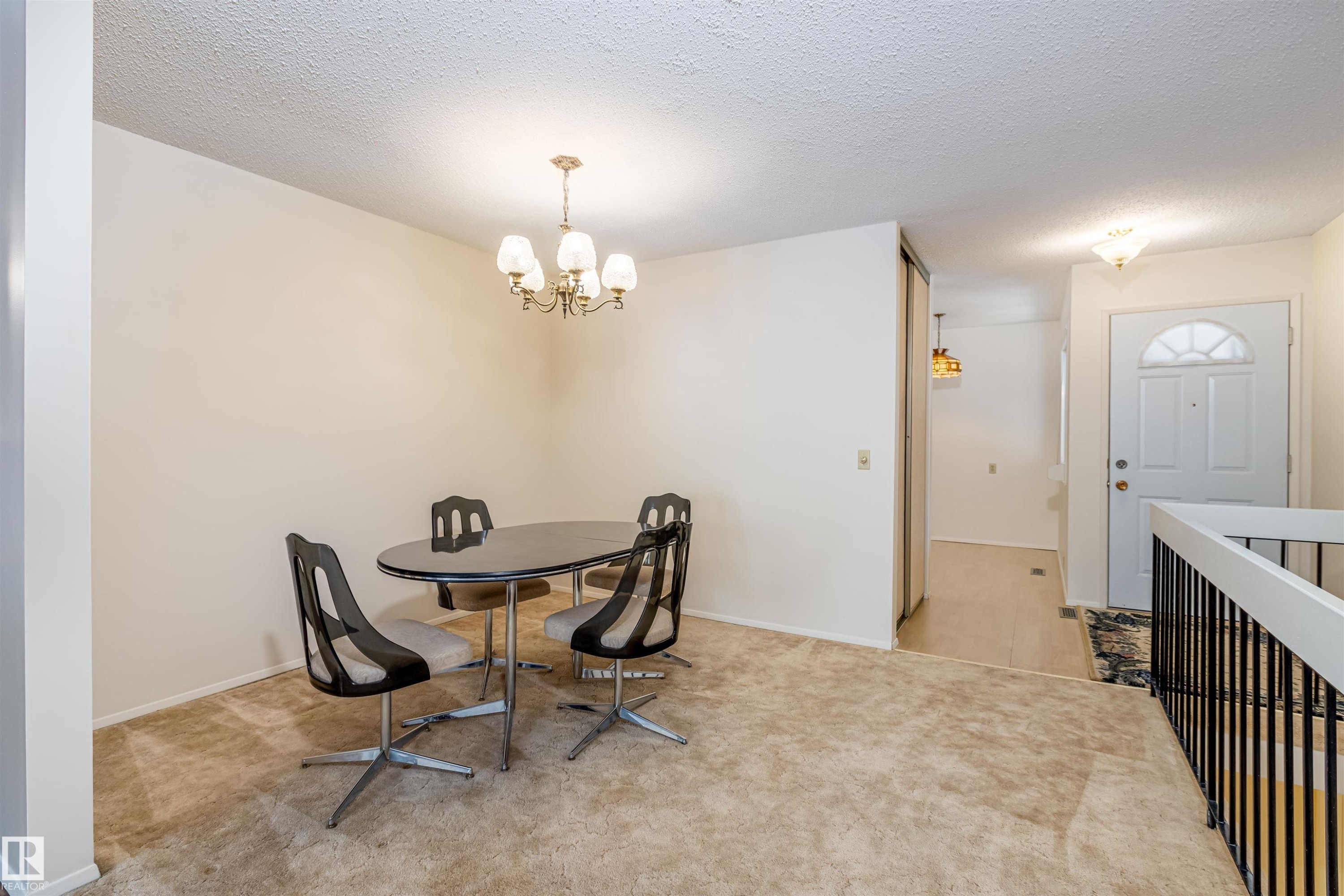 This room features a neutral color palette, a chandelier, and a carpeted floor - 108 Forest Grove, St. Albert, AB - Indoor Photo Showing Other Room