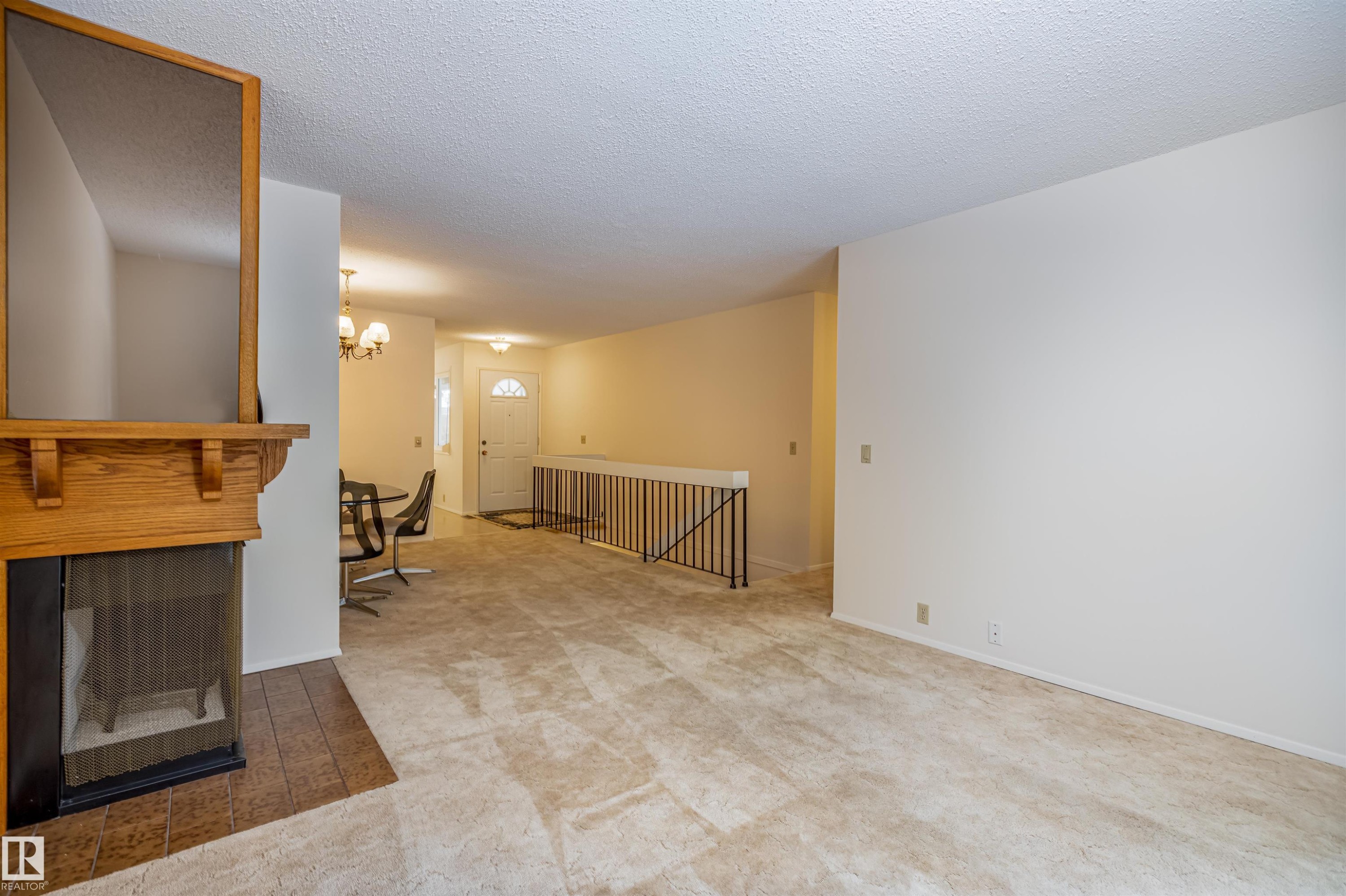 The living area features a fireplace with a wood mantel and a tiled hearth - 108 Forest Grove, St. Albert, AB - Indoor Photo Showing Other Room With Fireplace