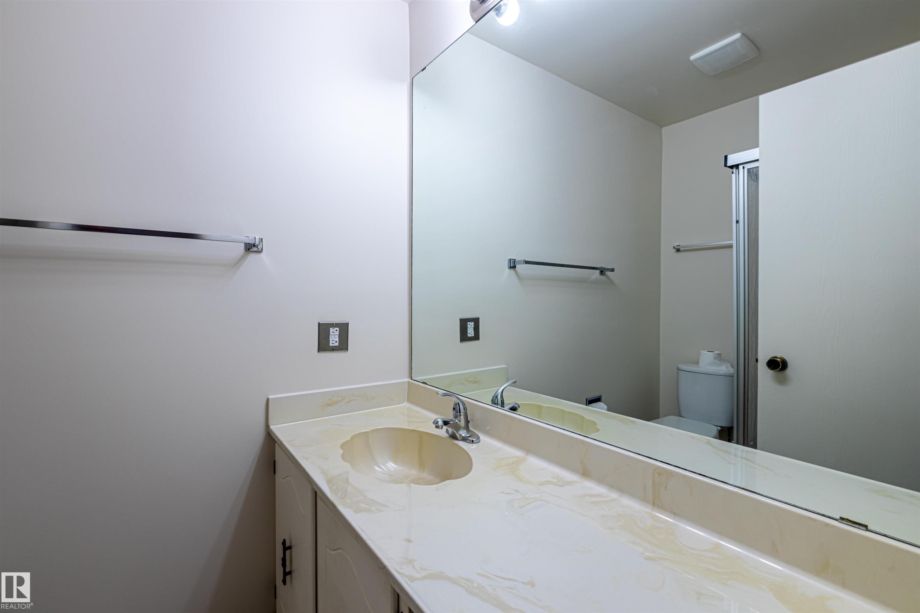 Bathroom vanity with an integrated sink and an expansive mirror - 108 Forest Grove, St. Albert, AB - Indoor Photo Showing Bathroom