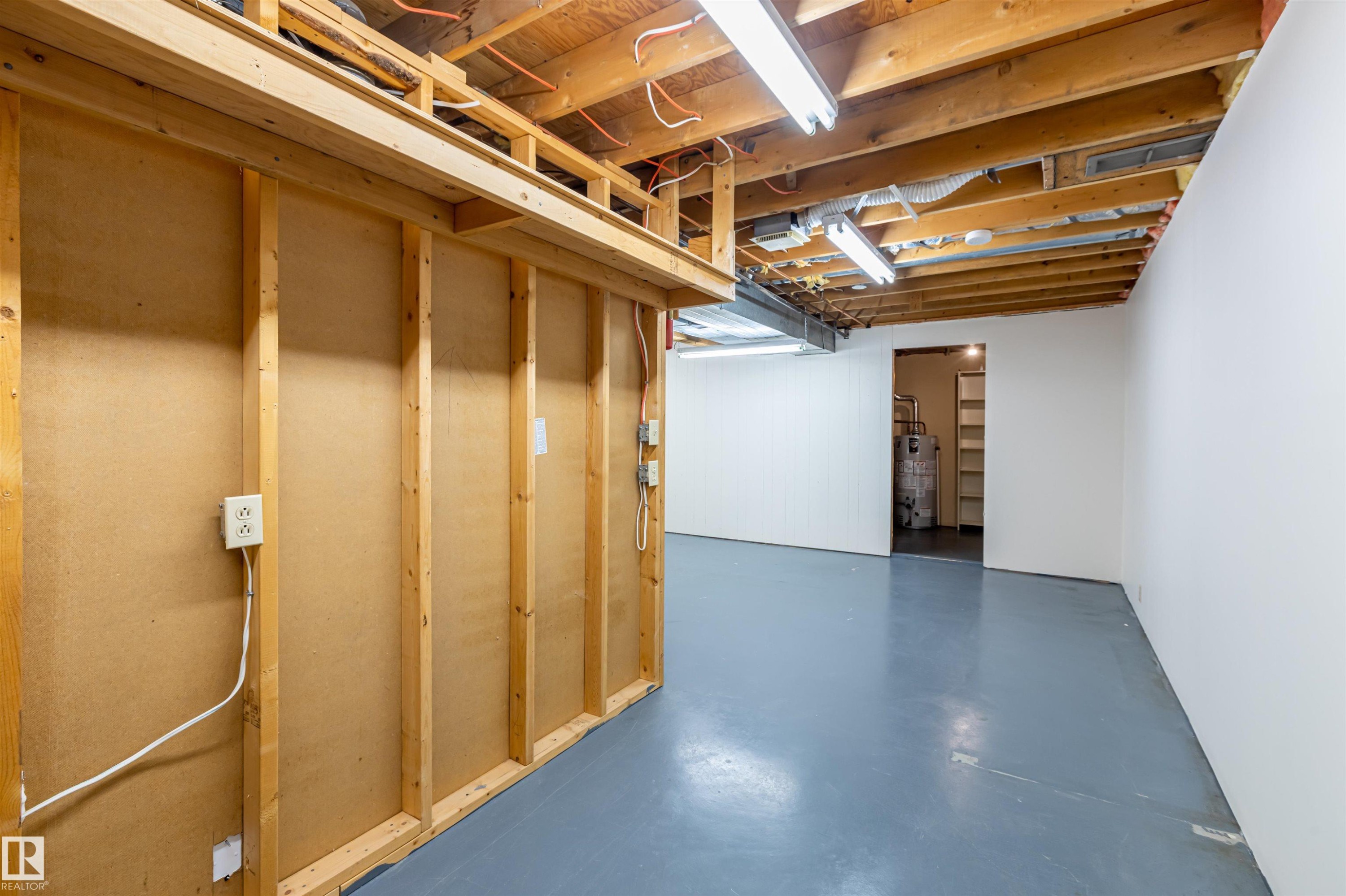 The property features an unfinished basement with exposed wooden joists and a painted concrete floor - 108 Forest Grove, St. Albert, AB - Indoor Photo Showing Basement