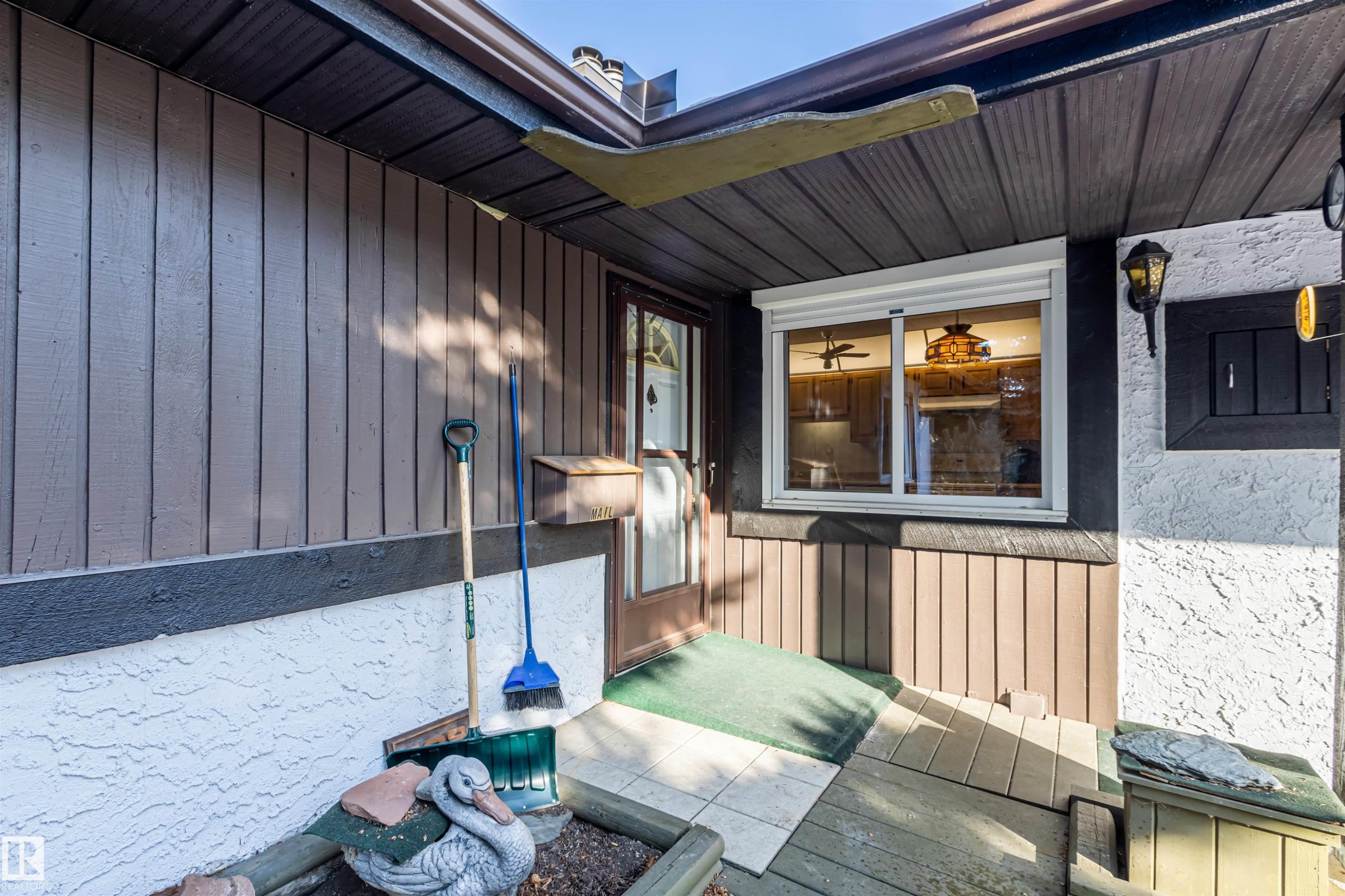 The property features exterior wood siding, a front entry door with a glass insert, and a window with a roll-down shutter - 108 Forest Grove, St. Albert, AB - Outdoor With Exterior