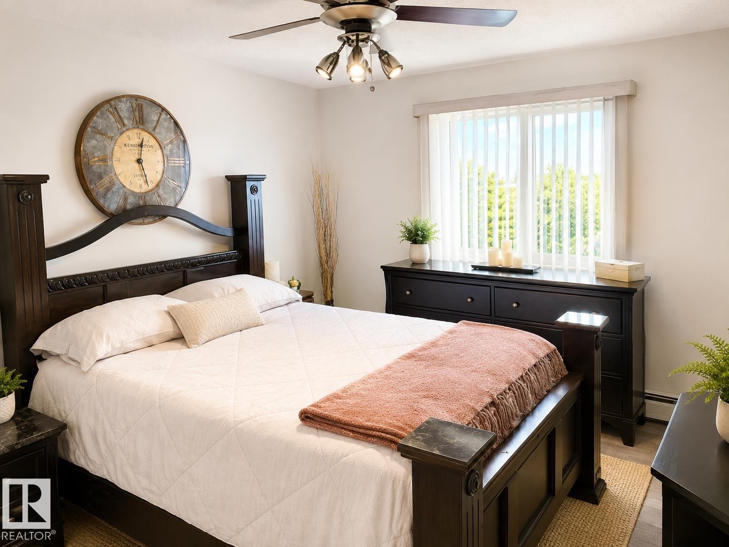 Bright room featuring a large window with vertical blinds, a ceiling fan with integrated lighting, and wood-finish flooring - 336 9525 162 Avenue, Edmonton, AB - Indoor Photo Showing Bedroom