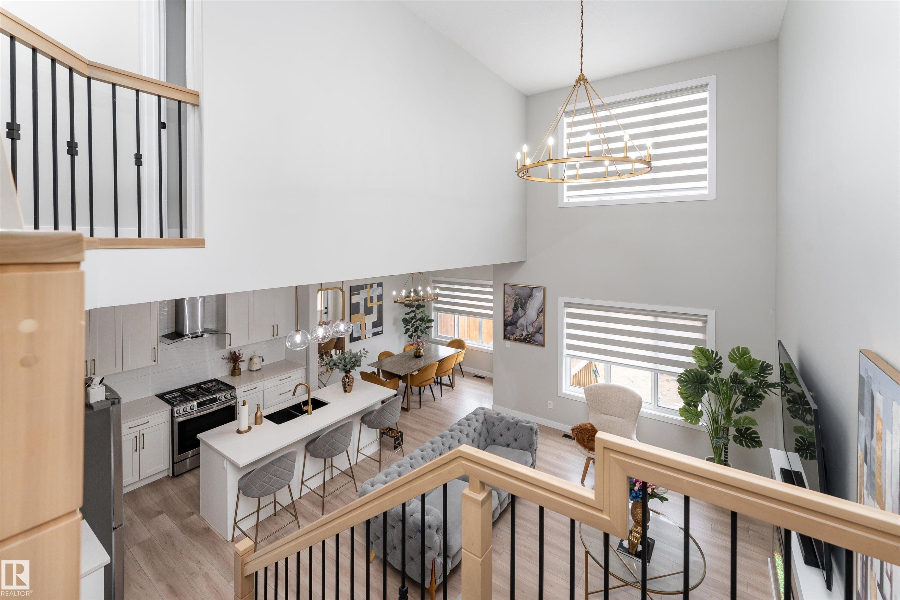 The property features a bright and spacious open concept layout with high ceilings and large windows, allowing for ample natural light - 993 Berg Pl, Leduc, AB - Indoor Photo Showing Other Room