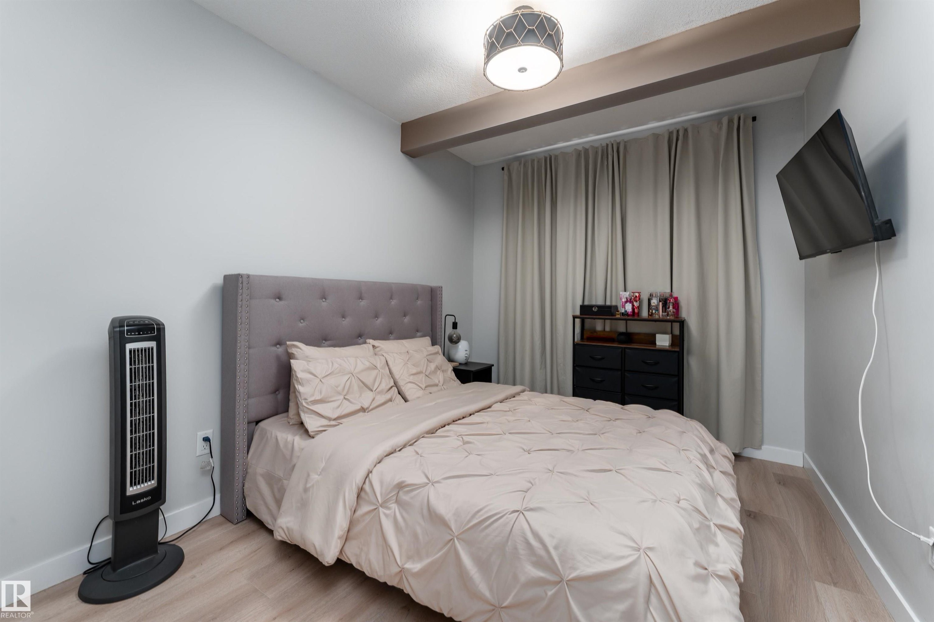 The bedroom features light-colored walls and flooring, with a tufted headboard and light-colored curtains - 993 Berg Pl, Leduc, AB - Indoor Photo Showing Bedroom