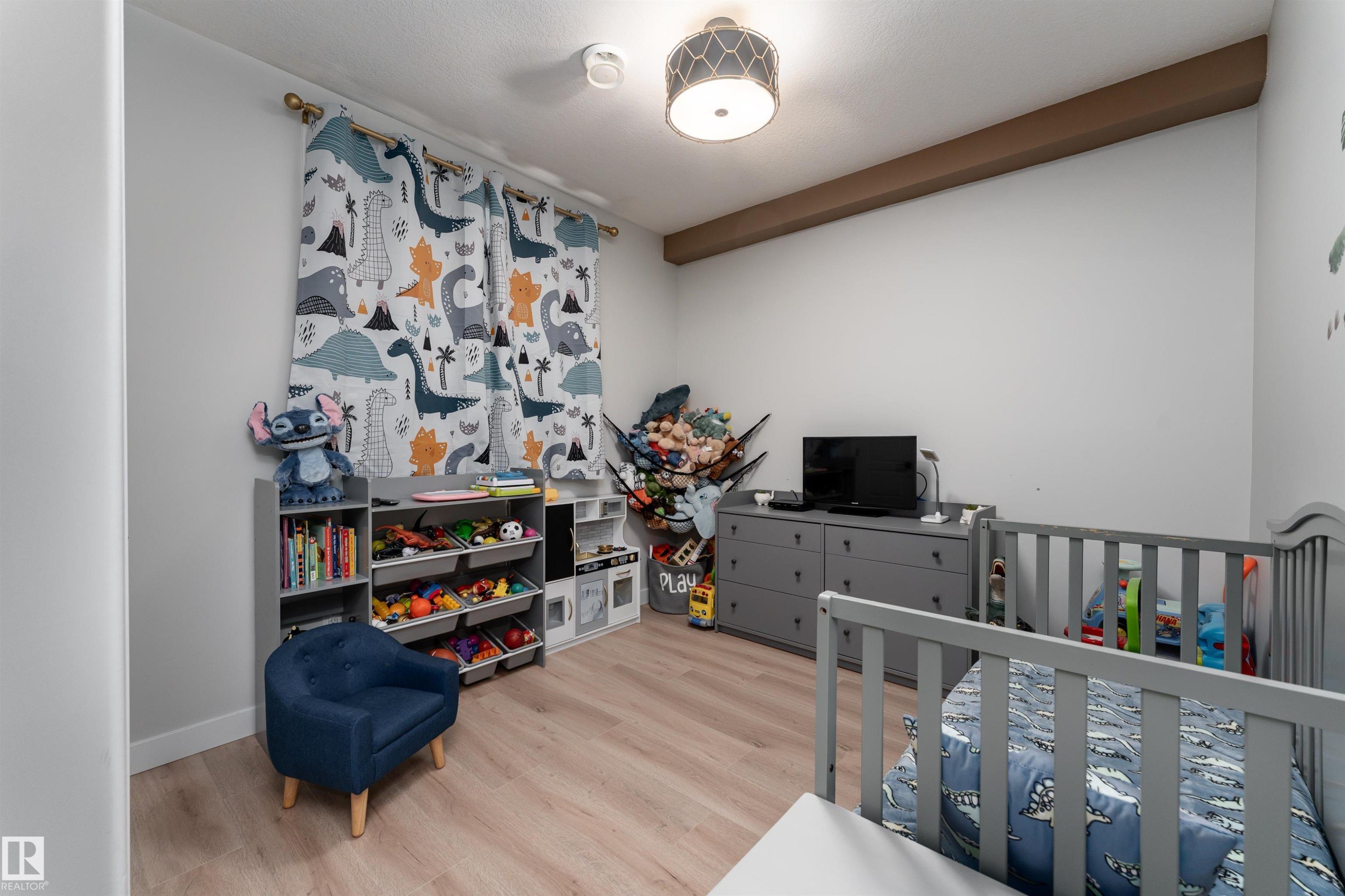 This room features light-colored flooring, neutral wall paint, and a decorative ceiling light fixture - 993 Berg Pl, Leduc, AB - Indoor Photo Showing Other Room
