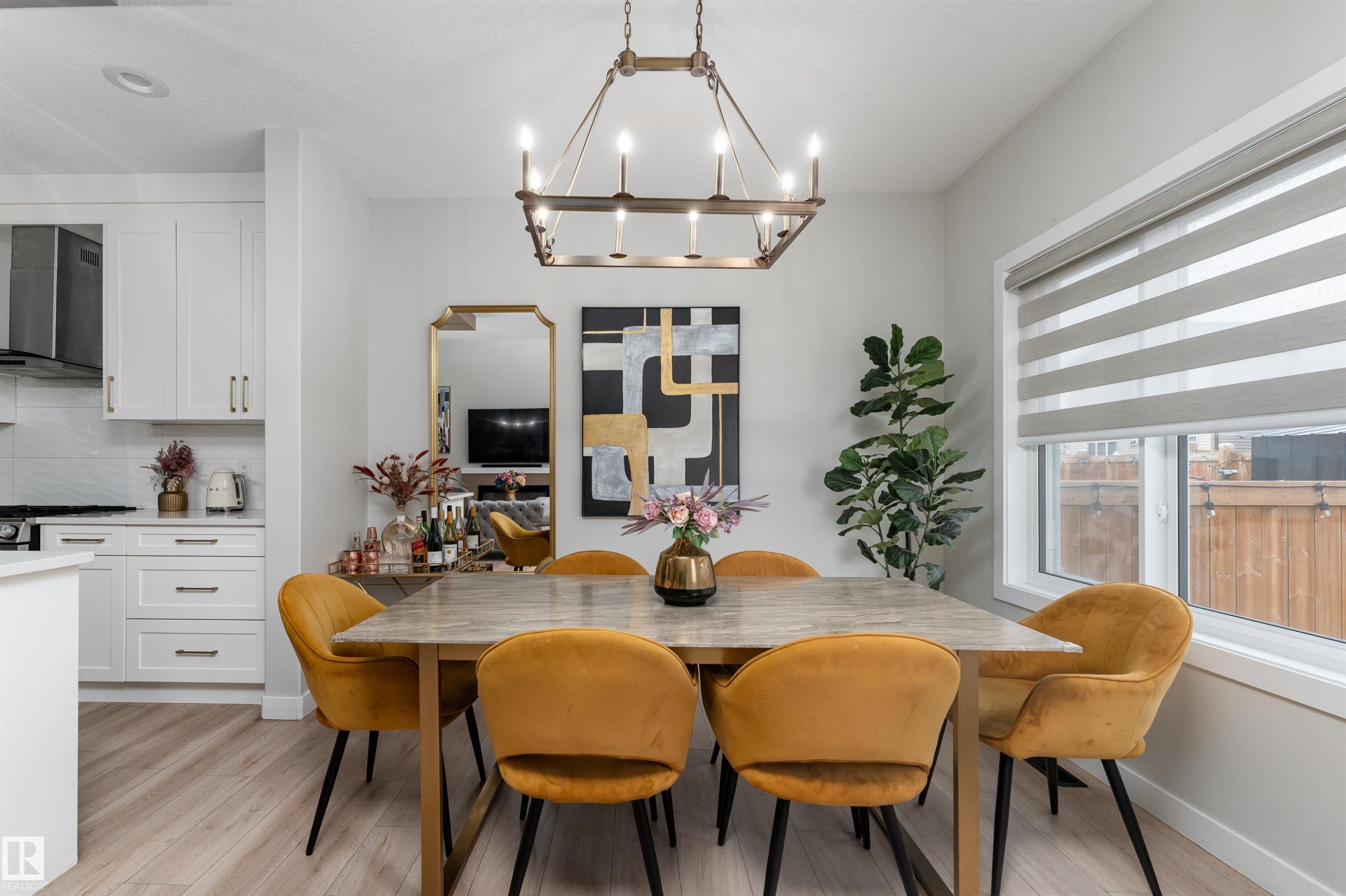 This dining area features light-toned flooring, a rectangular dining table, and a window with blinds - 993 Berg Pl, Leduc, AB - Indoor Photo Showing Dining Room
