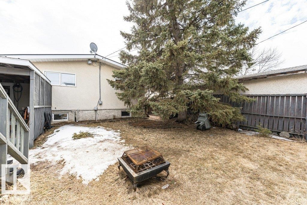 The property features a spacious yard with a mature evergreen tree and a wooden fence - 8 Duke Drive, Lamont, AB - Outdoor