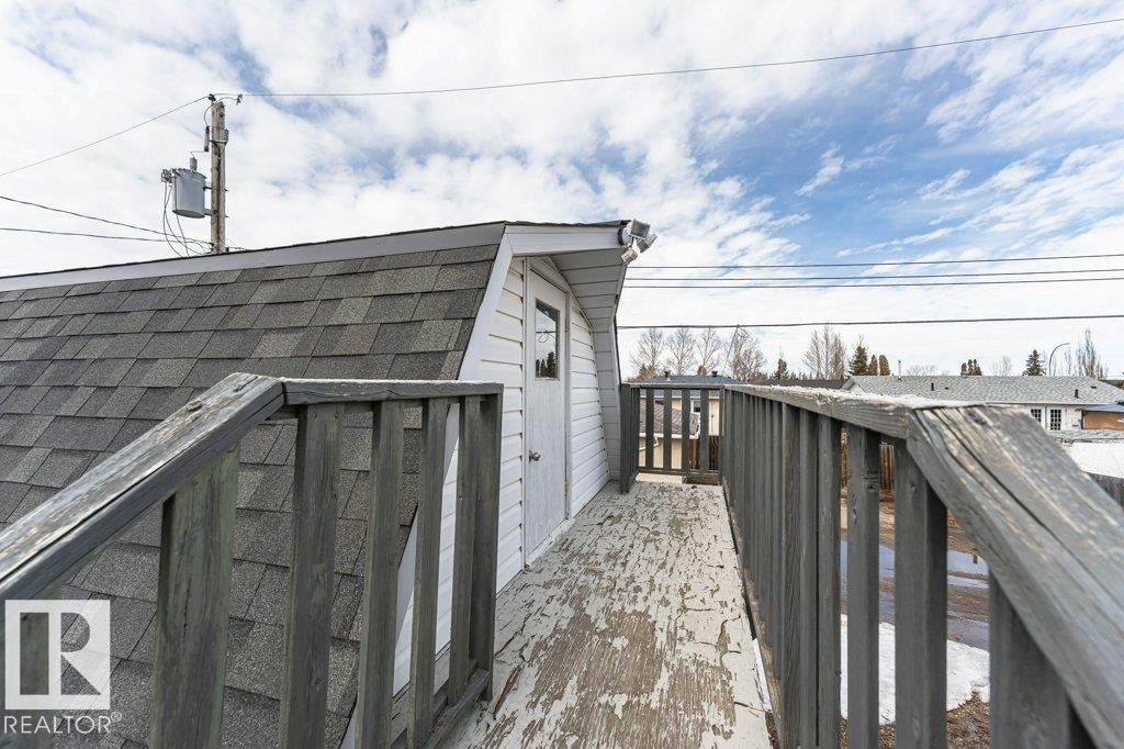 The property includes a structure featuring a shingled roof and white siding, with a white door visible - 8 Duke Drive, Lamont, AB - Outdoor