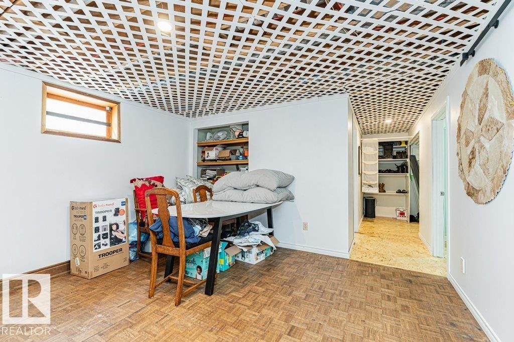 This room features white walls, a window with a wood trim, and a geometrically patterned ceiling - 8 Duke Drive, Lamont, AB - Indoor Photo Showing Other Room
