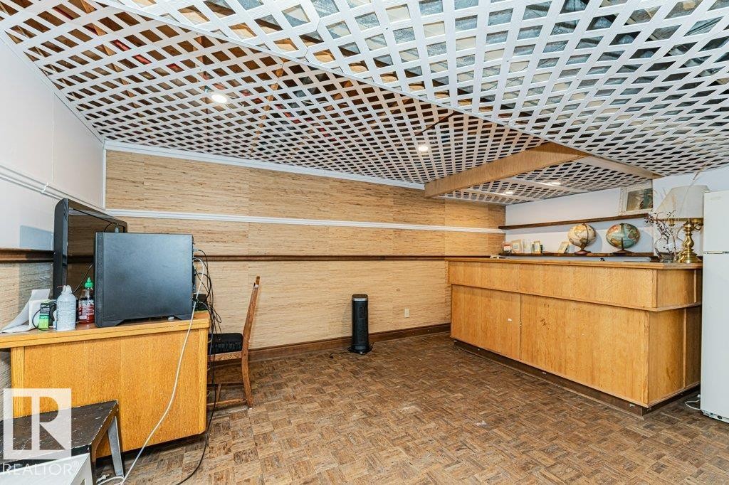 Recreation room featuring a patterned ceiling, wood paneling, and a built-in wooden counter - 8 Duke Drive, Lamont, AB - Photo Showing Other Room
