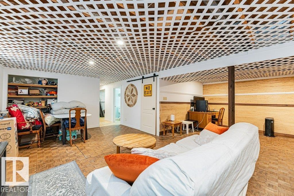 This versatile space features a unique lattice-patterned ceiling, light-colored walls, and a warm-toned parquet floor - 8 Duke Drive, Lamont, AB - Indoor