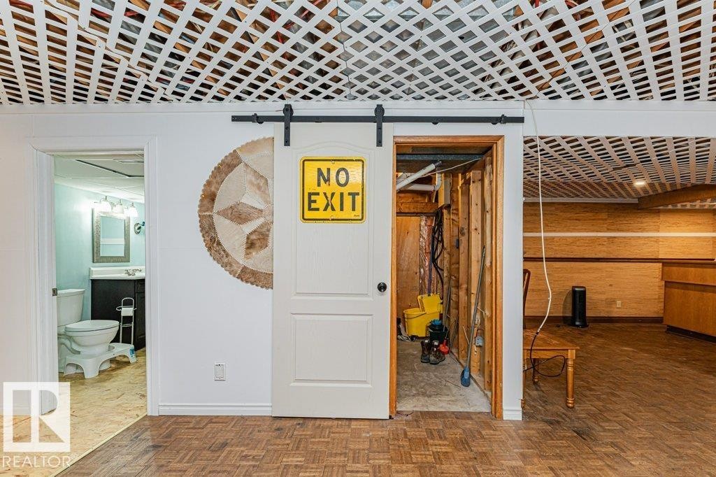 This space features parquet wood flooring and a distinctive lattice ceiling - 8 Duke Drive, Lamont, AB - Indoor Photo Showing Other Room
