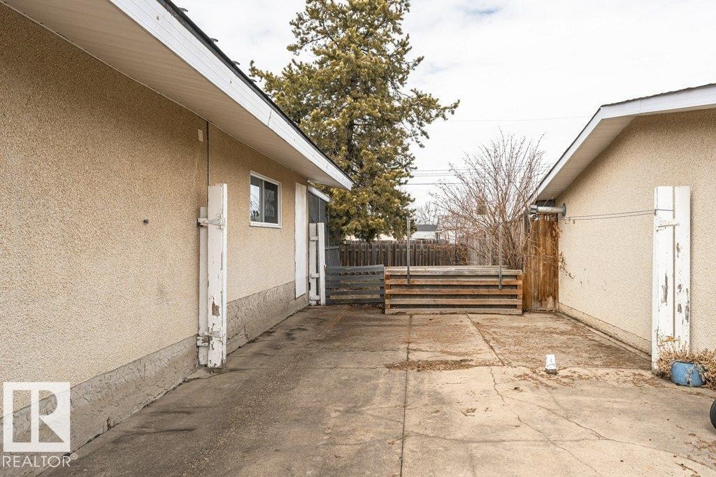 The property features stucco exterior siding and a concrete surface courtyard - 8 Duke Drive, Lamont, AB - Outdoor With Exterior
