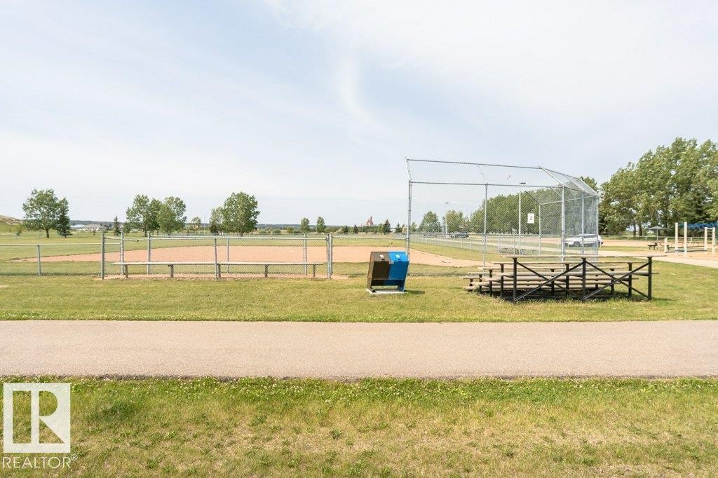 Enjoy the convenience of nearby recreational facilities, including a baseball diamond with a backstop, spectator seating, and a dugout, all set within a spacious grassy park area - 8 Duke Drive, Lamont, AB - Outdoor