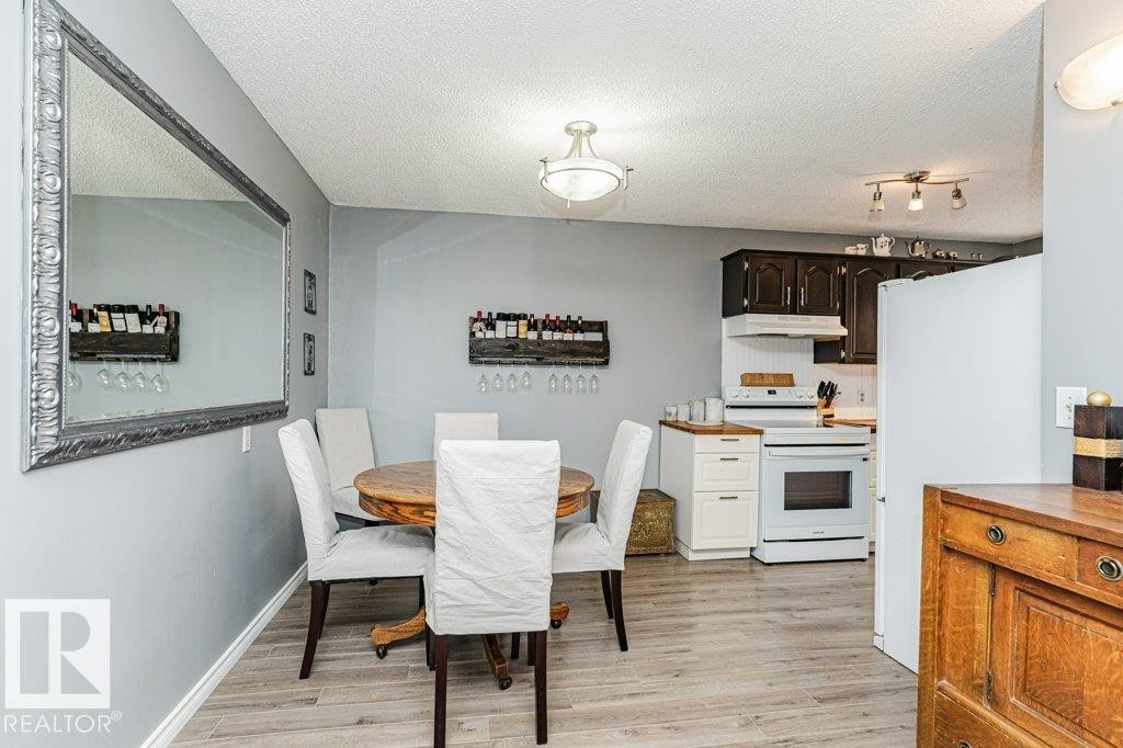 The property features light wood flooring throughout the dining area and kitchen - 8 Duke Drive, Lamont, AB - Indoor Photo Showing Kitchen