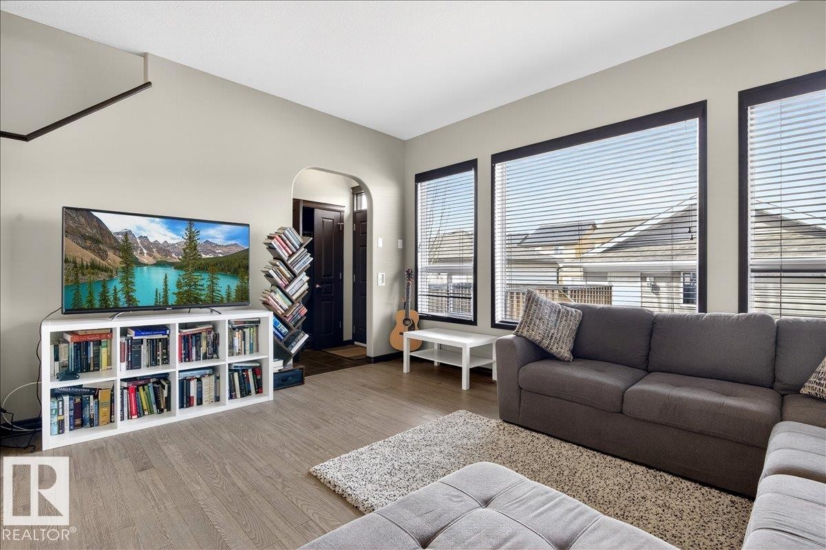 The living area features light-colored walls and flooring, complemented by large windows - 1530 Chapman Way, Edmonton, AB - Indoor Photo Showing Living Room