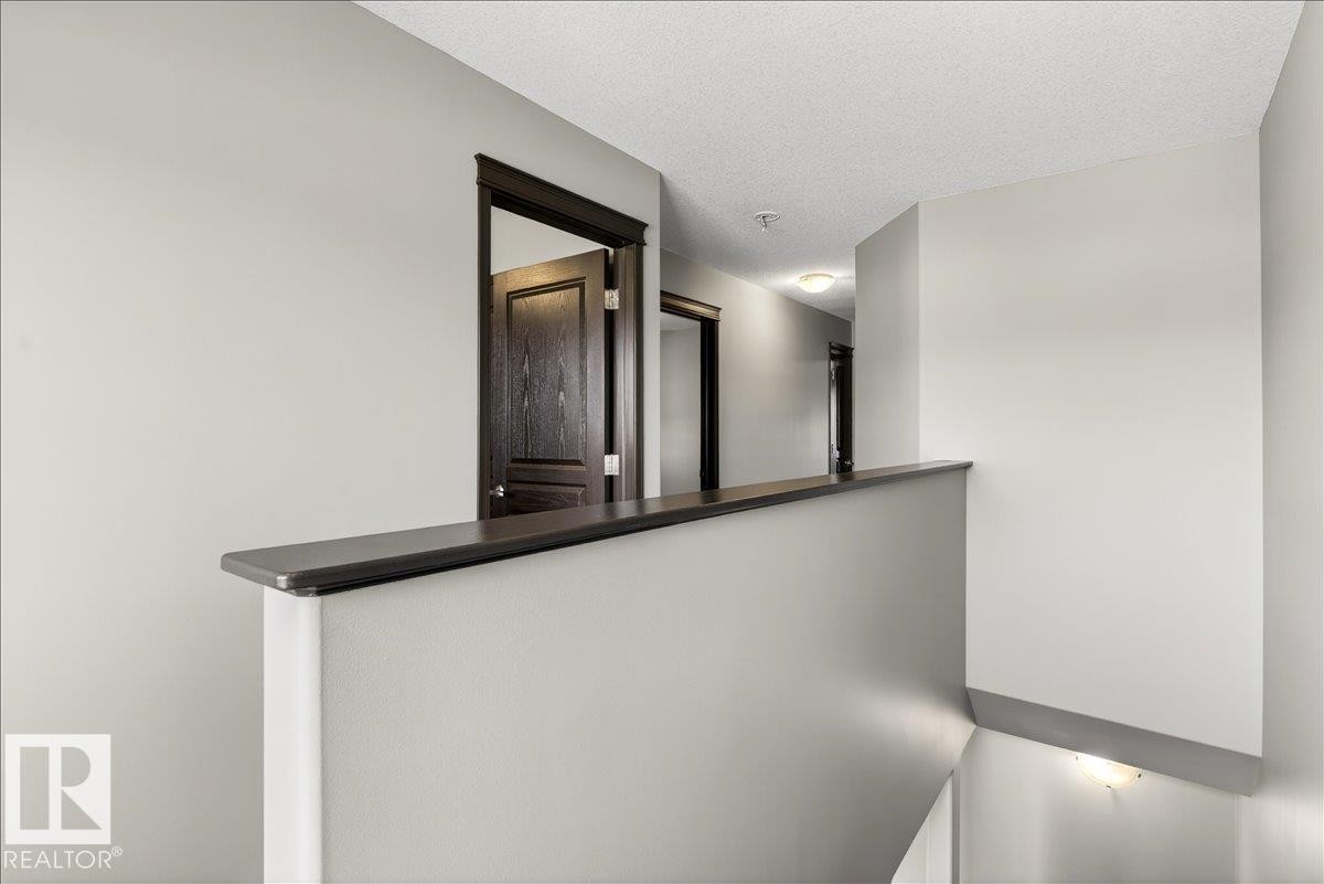 The property features a hallway with light gray walls, dark wood trim, and doors - 1530 Chapman Way, Edmonton, AB - Indoor Photo Showing Other Room