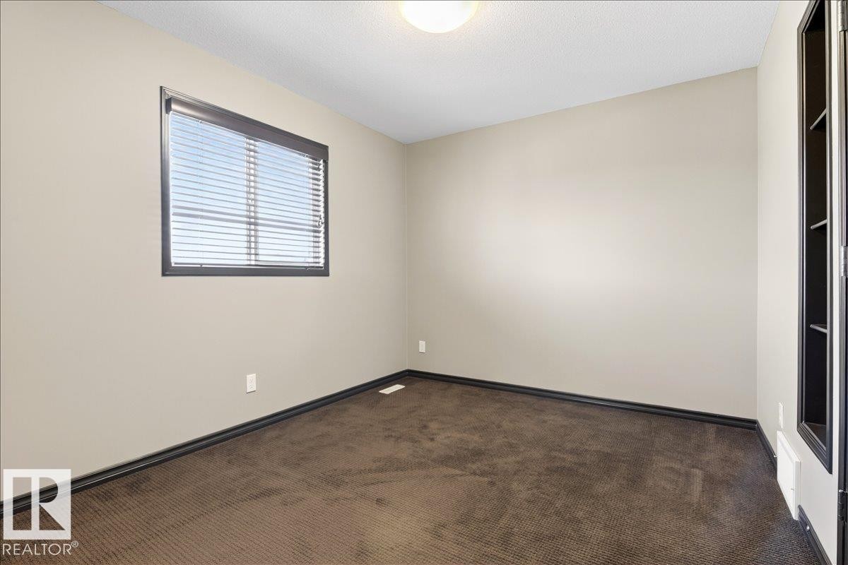This room features a window with horizontal blinds, carpeted flooring, and light-colored walls - 1530 Chapman Way, Edmonton, AB - Indoor Photo Showing Other Room