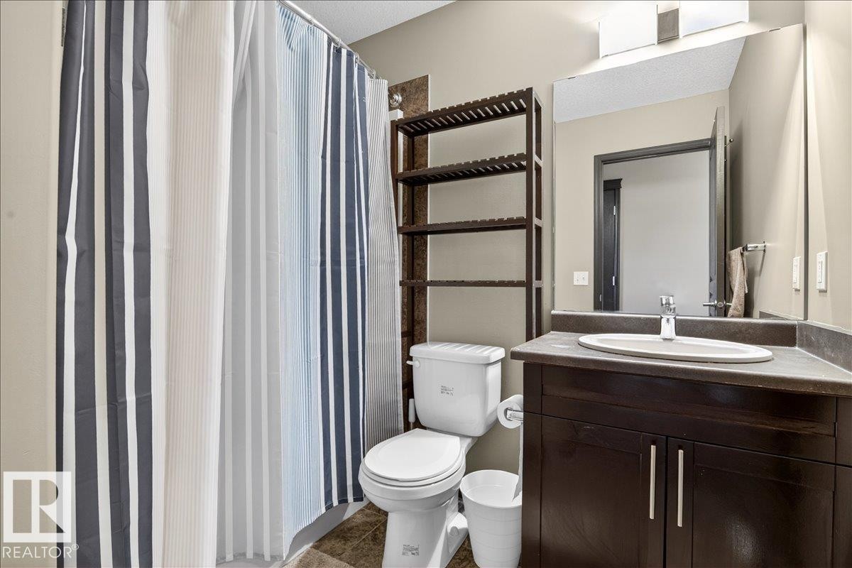 Bathroom with a dark wood vanity, a vessel sink, and a large mirror - 1530 Chapman Way, Edmonton, AB - Indoor Photo Showing Bathroom