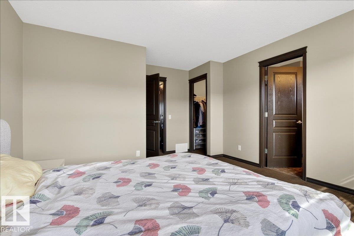 Bedroom featuring neutral-toned walls, dark trim, and dark doors - 1530 Chapman Way, Edmonton, AB - Indoor Photo Showing Bedroom