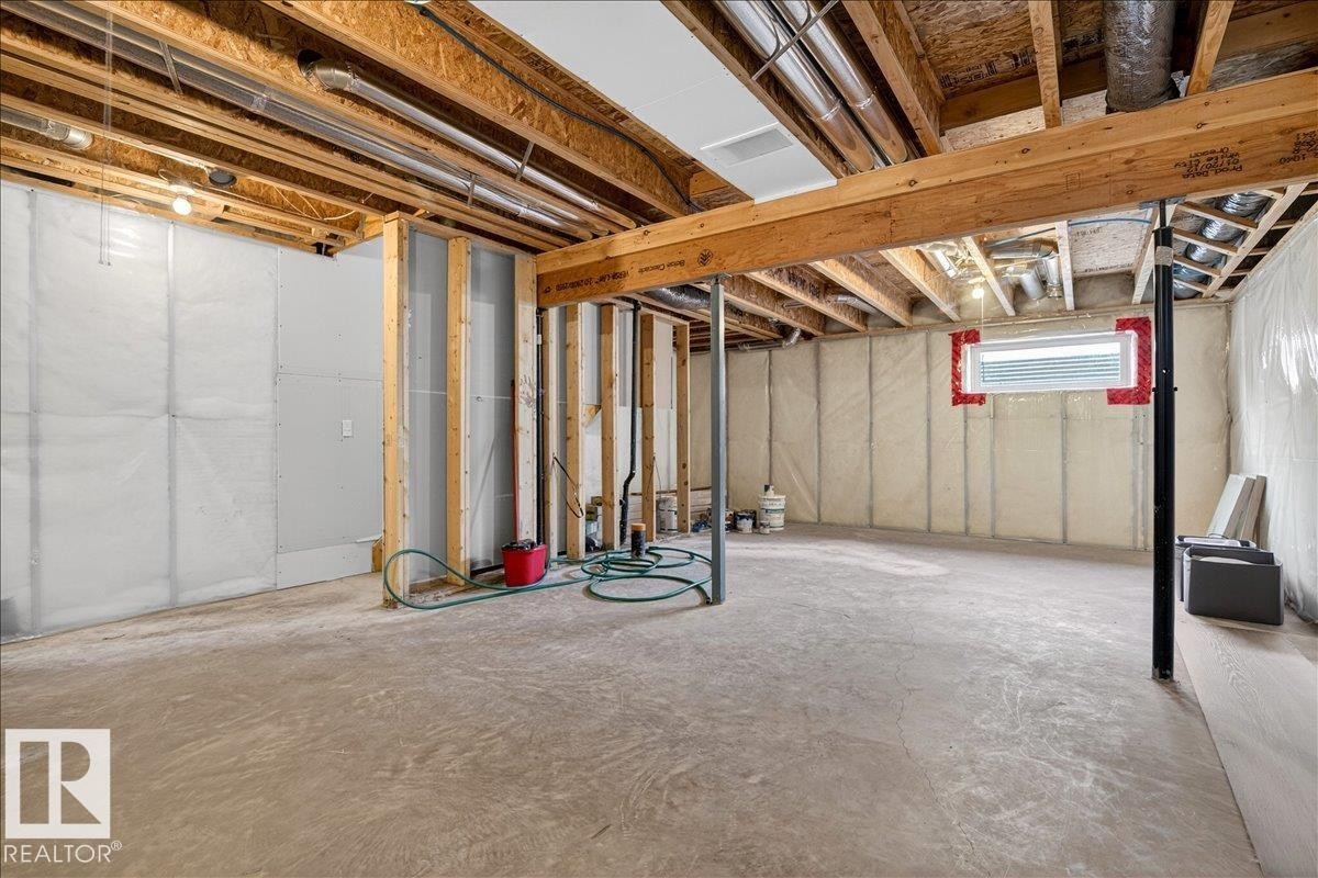 The property features an unfinished basement with exposed wooden beams and structural supports, a concrete floor, and a visible window opening - 1530 Chapman Way, Edmonton, AB - Indoor Photo Showing Basement