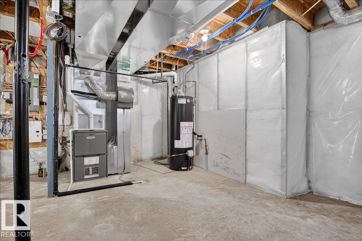 The property features a utility area with a furnace, water heater, and exposed ceiling joists - 1530 Chapman Way, Edmonton, AB - Indoor Photo Showing Basement