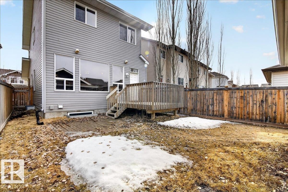 The property features a private backyard with a wooden deck, a wooden fence, and a grass area - 1530 Chapman Way, Edmonton, AB - Outdoor With Exterior