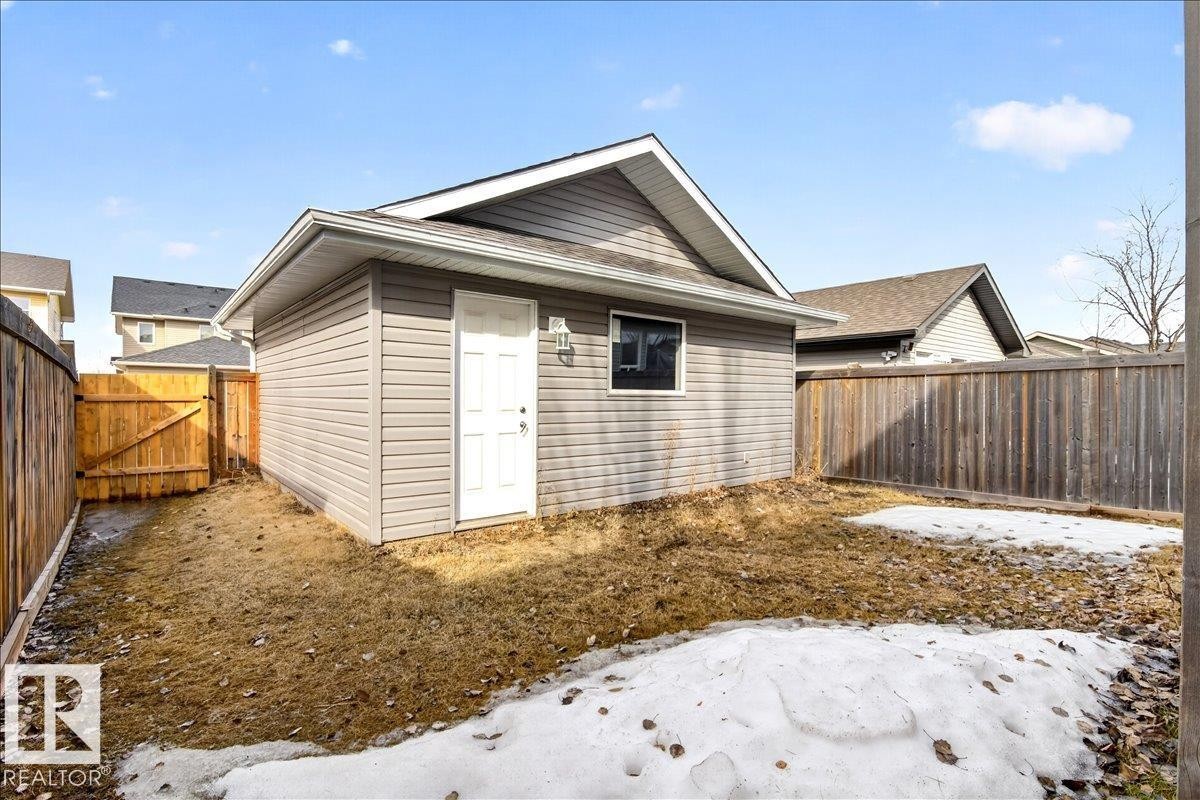 The property features a detached building with grey siding, a white door, and a single window - 1530 Chapman Way, Edmonton, AB - Outdoor