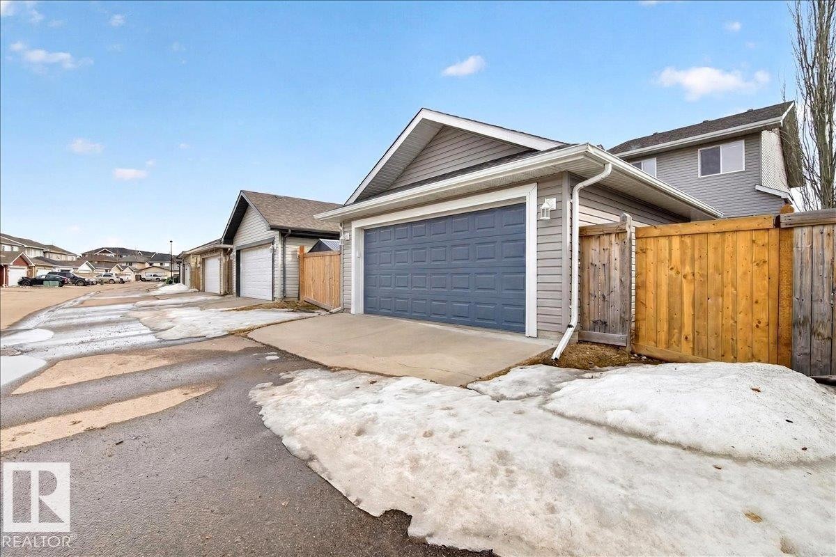 The property includes a detached garage with a grey garage door and light grey siding - 1530 Chapman Way, Edmonton, AB - Outdoor